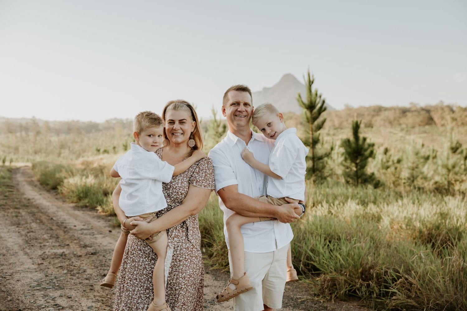 Candid family portraits captured against a scenic outdoor backdrop during golden hour.