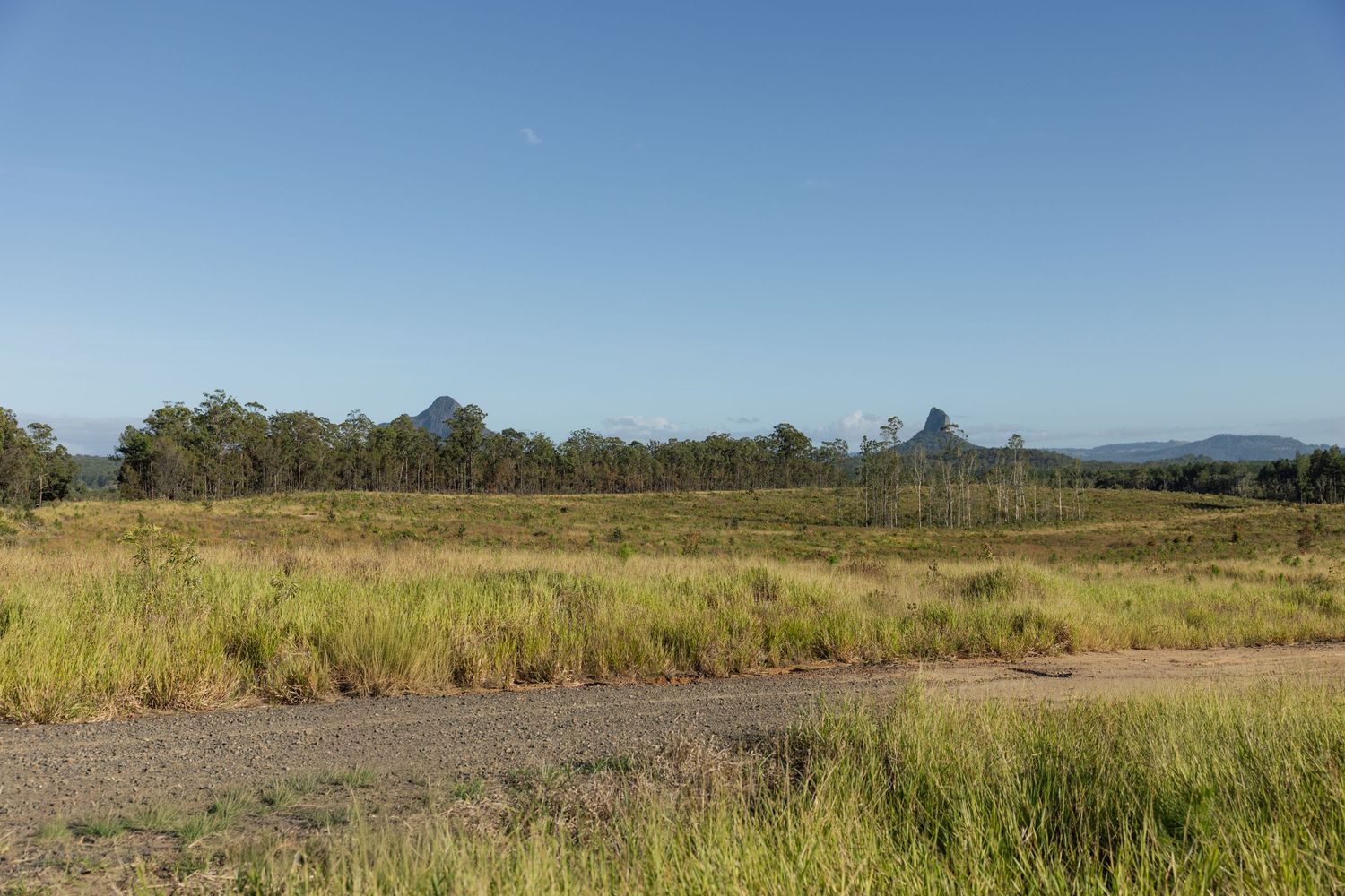 Wide panoramic view of mountain ranges and grasslands stretching to the horizon.