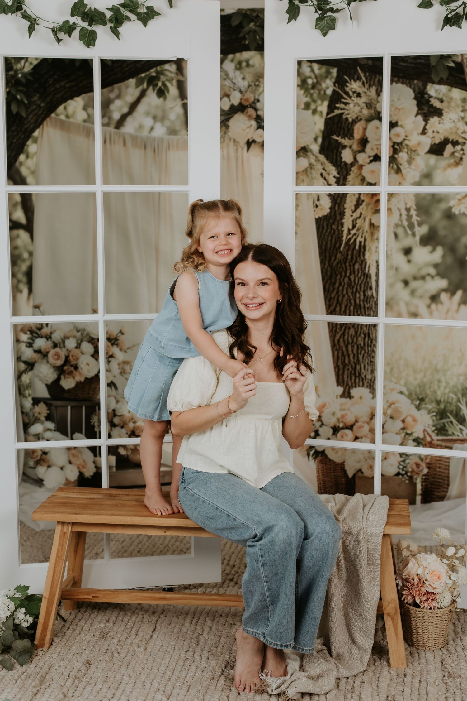 Sweet candid portrait by a window with natural light and floral backdrop.