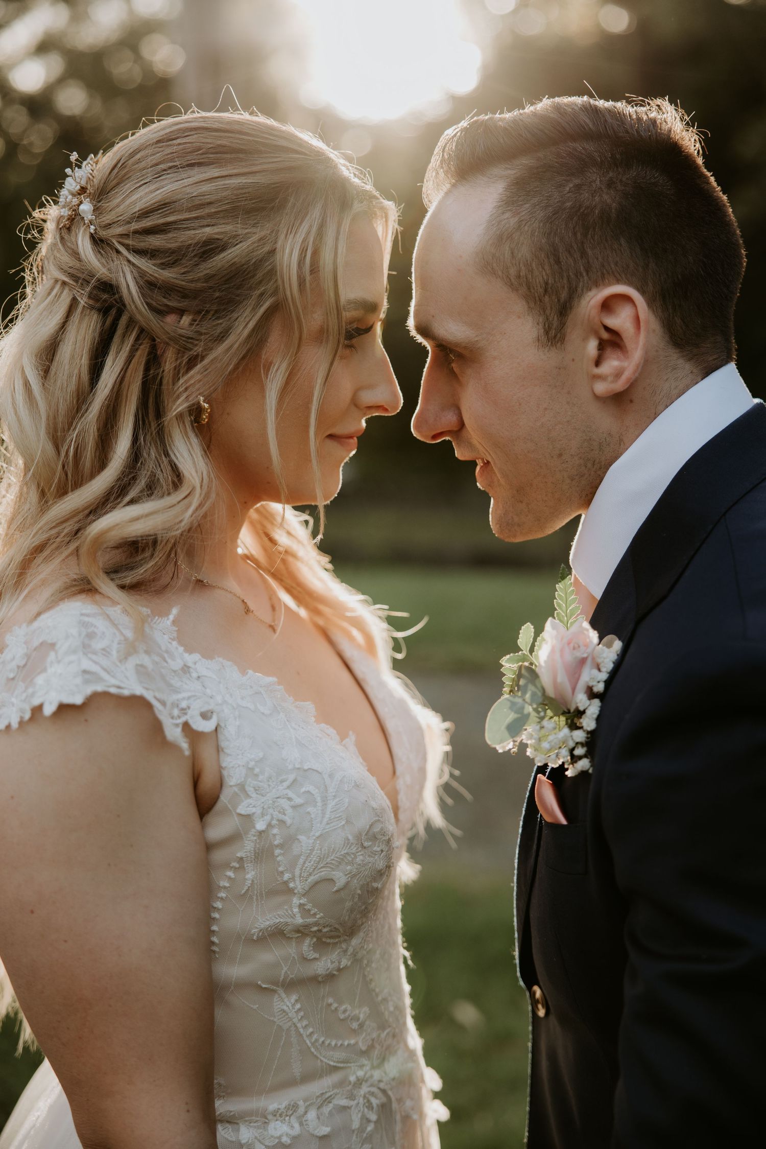 Intimate sunset portrait of newlyweds with golden light creating romantic backlighting.