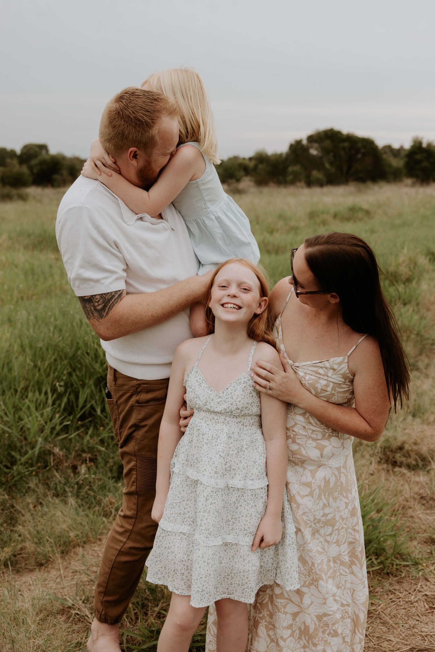 Candid family moments captured in a rustic field setting during golden hour.