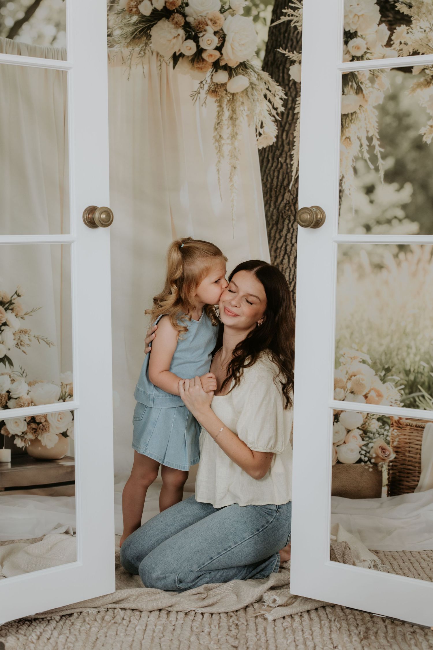 Sweet candid moment shared between two people with floral decor and white windows.