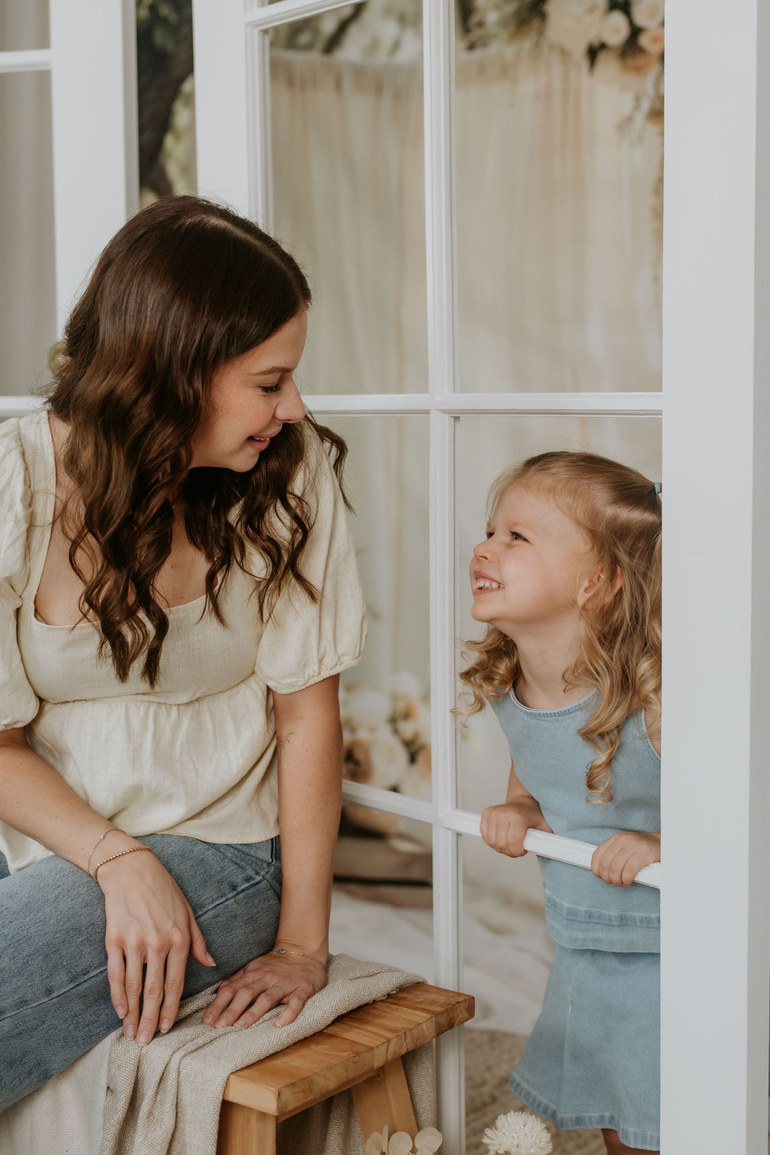 Joyful interaction through window panes with soft natural lighting.