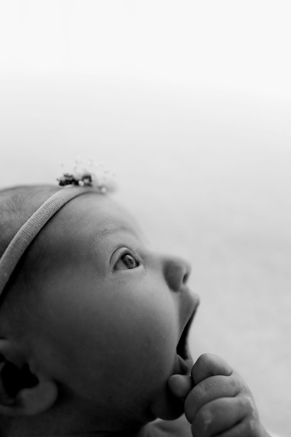 Close-up black and white profile shots of an infant's face against a light background.