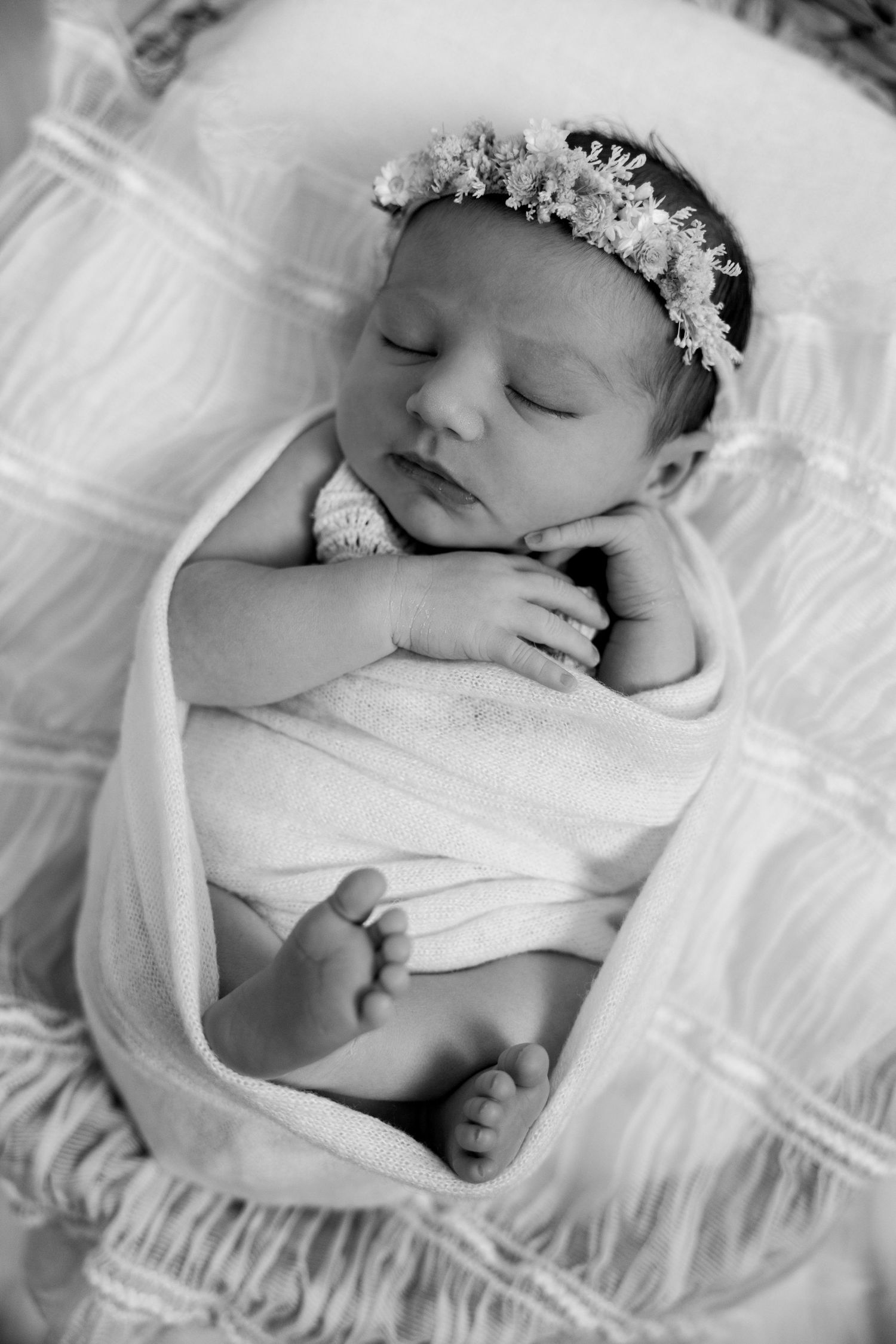 Sleeping newborn baby in soft white styling during studio newborn photography session