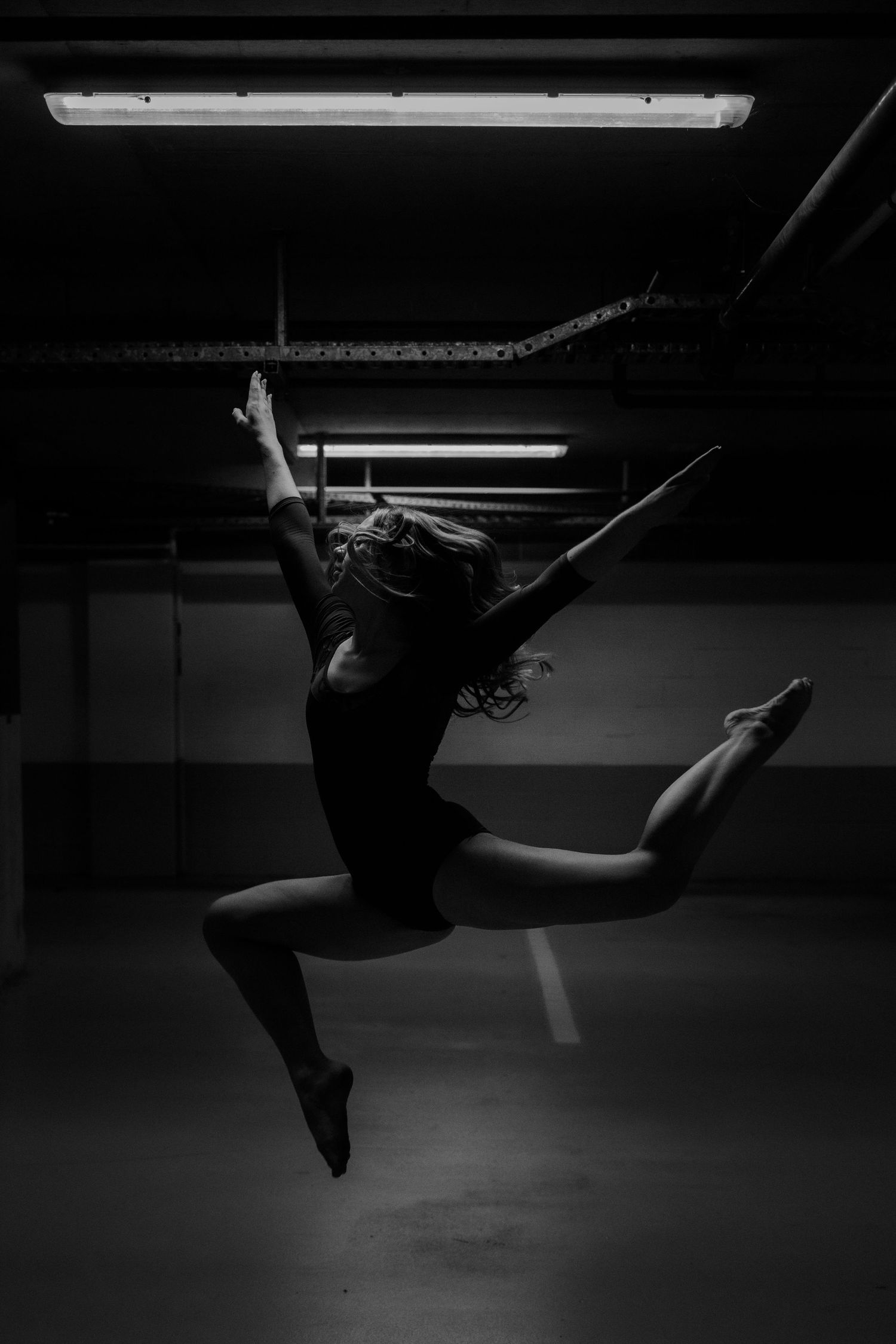 Dramatic black and white dance sequence showing aerial movements in dark studio.