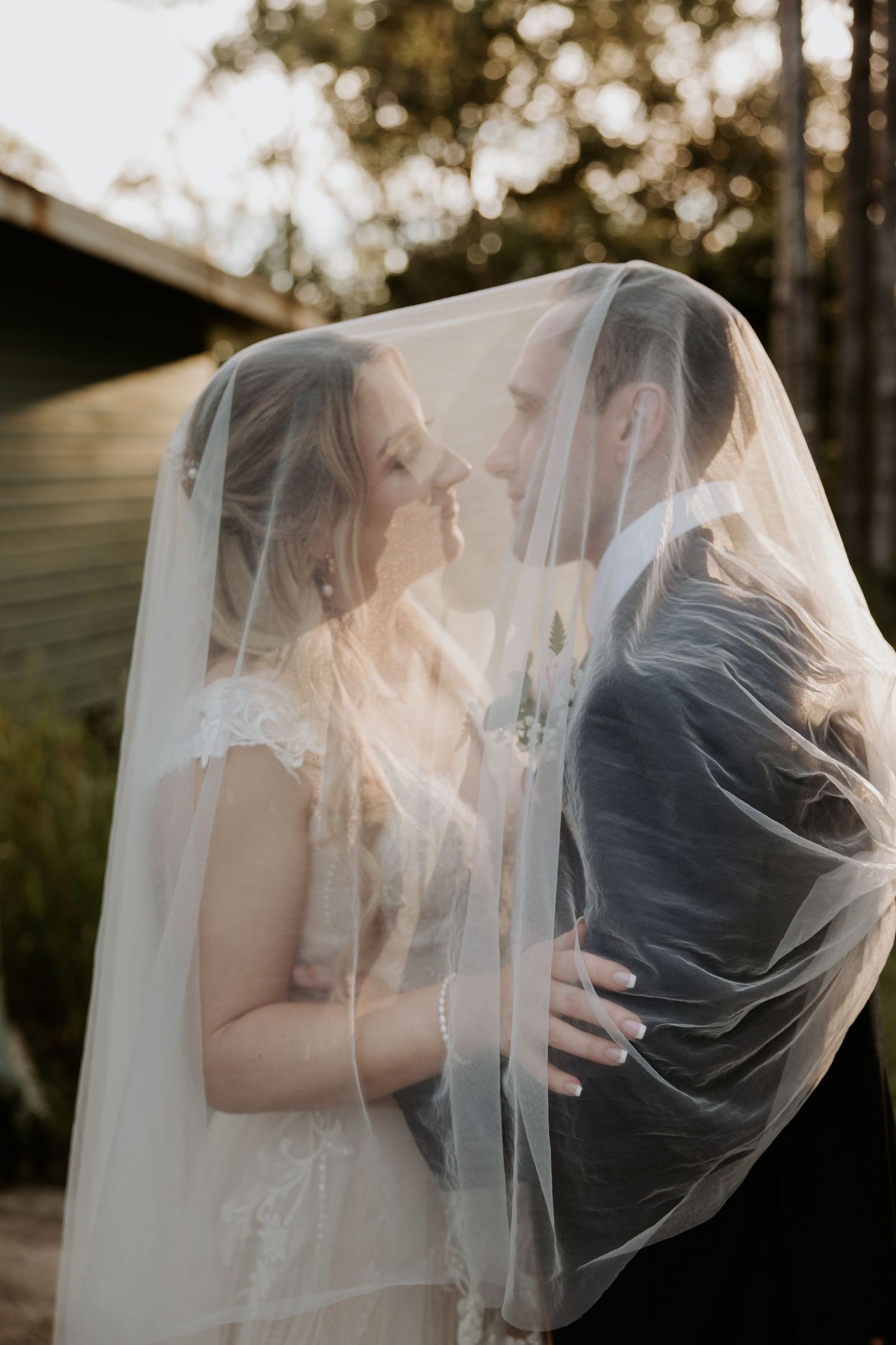 Artistic wedding portrait sequence showing couple sharing tender moments under flowing white veil.