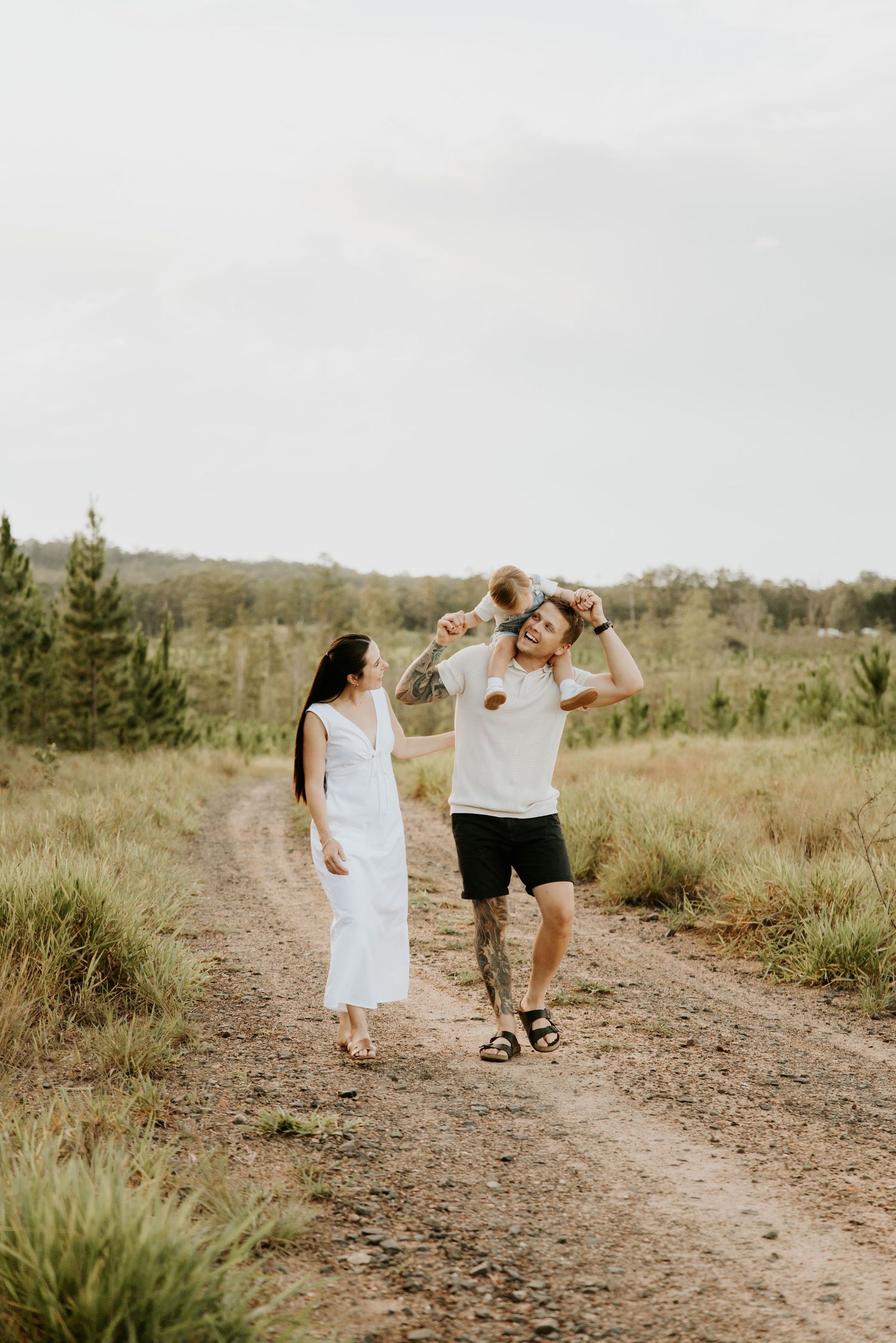 Couple enjoying playful moment while walking on rural trail.