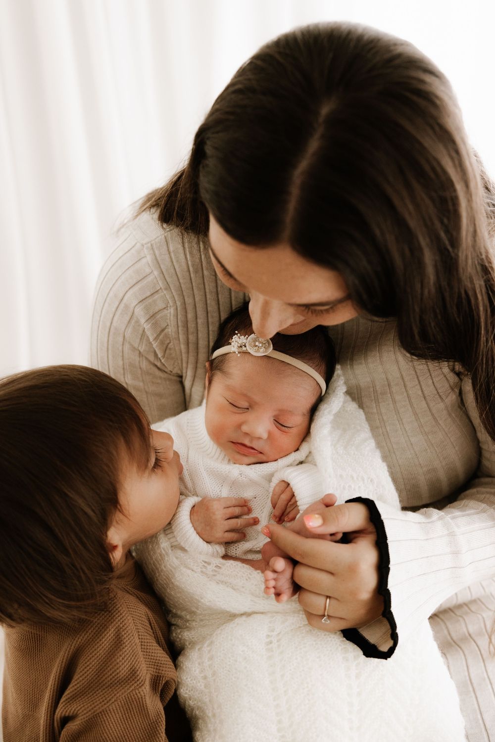 Intimate family moments captured in sepia tones showing gentle interaction.