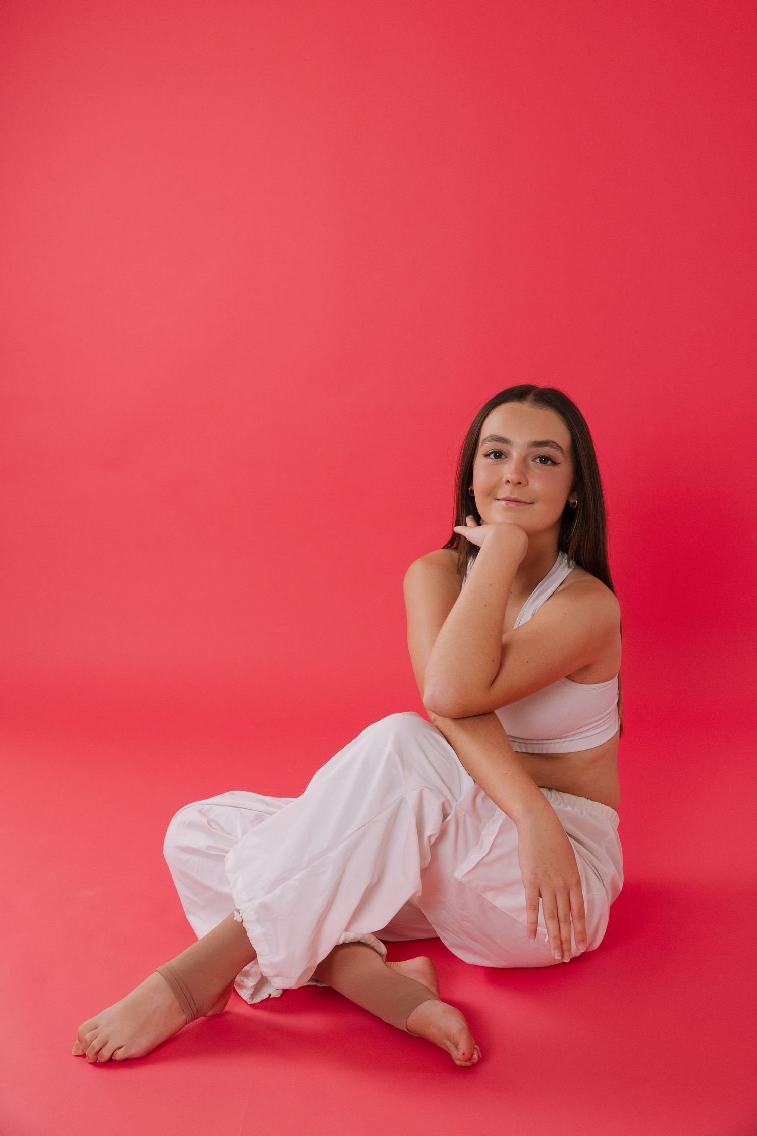 Artistic portrait series of a woman in white clothing against a vibrant red background.