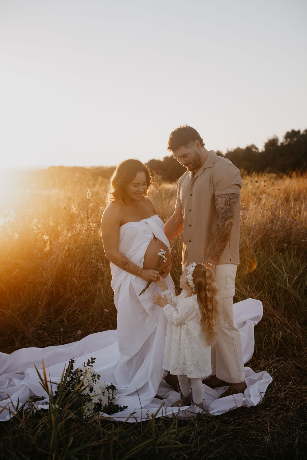 Family enjoying tender moments together during golden hour outdoor photo session.