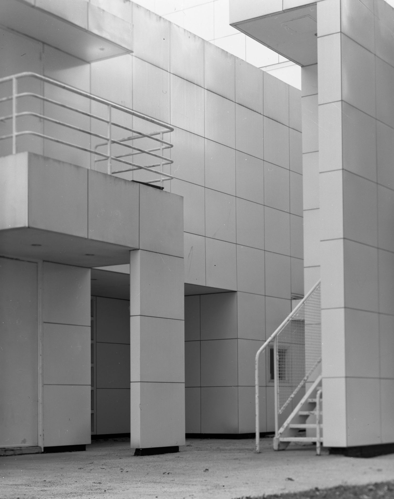 Film photograph of a mysterious white tiled building with stairs and balcony