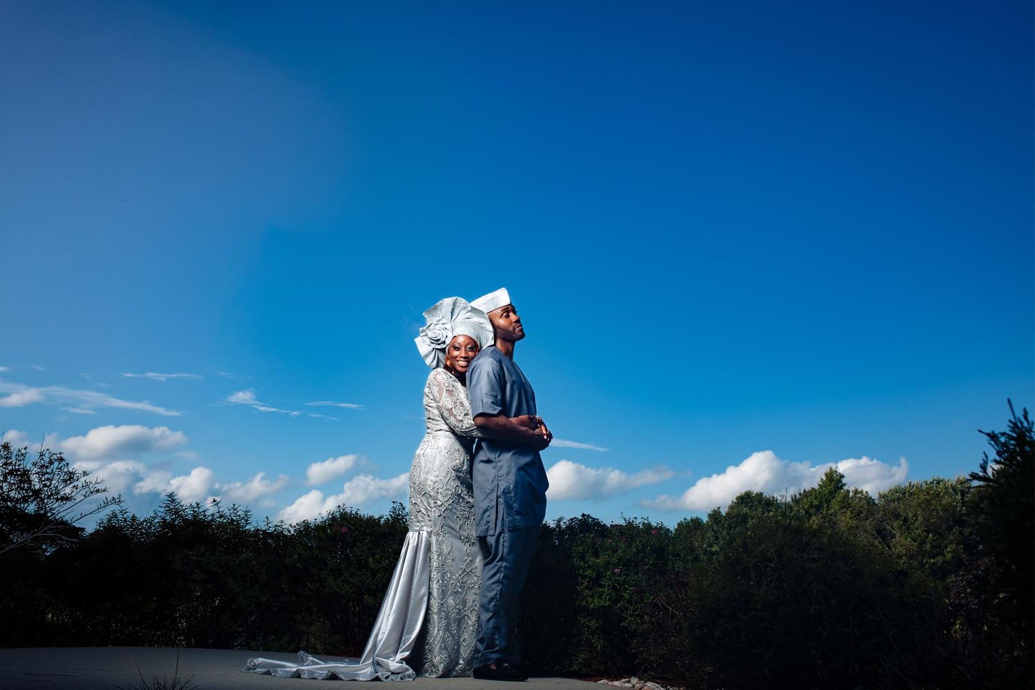 Dramatic sky portraits of a couple on their wedding day with clouds in the background.