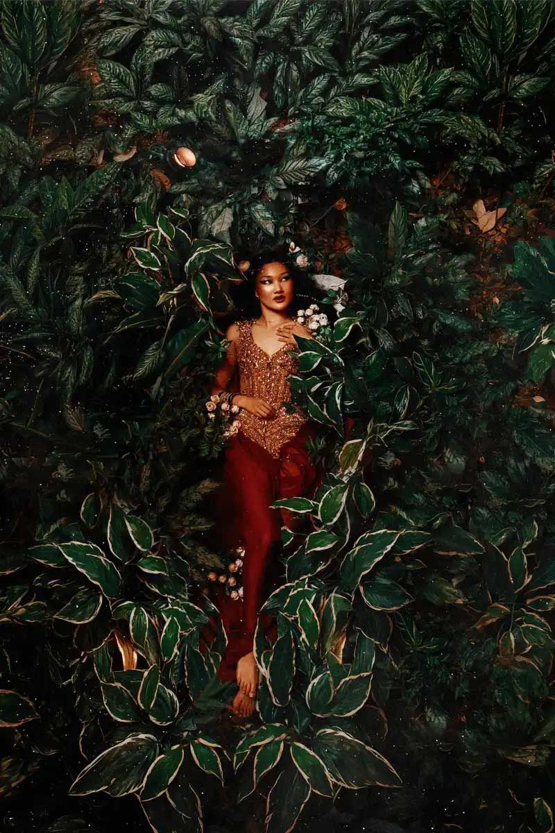 A fashion portrait in a lush garden setting featuring a brown sequined dress amidst tropical foliage.