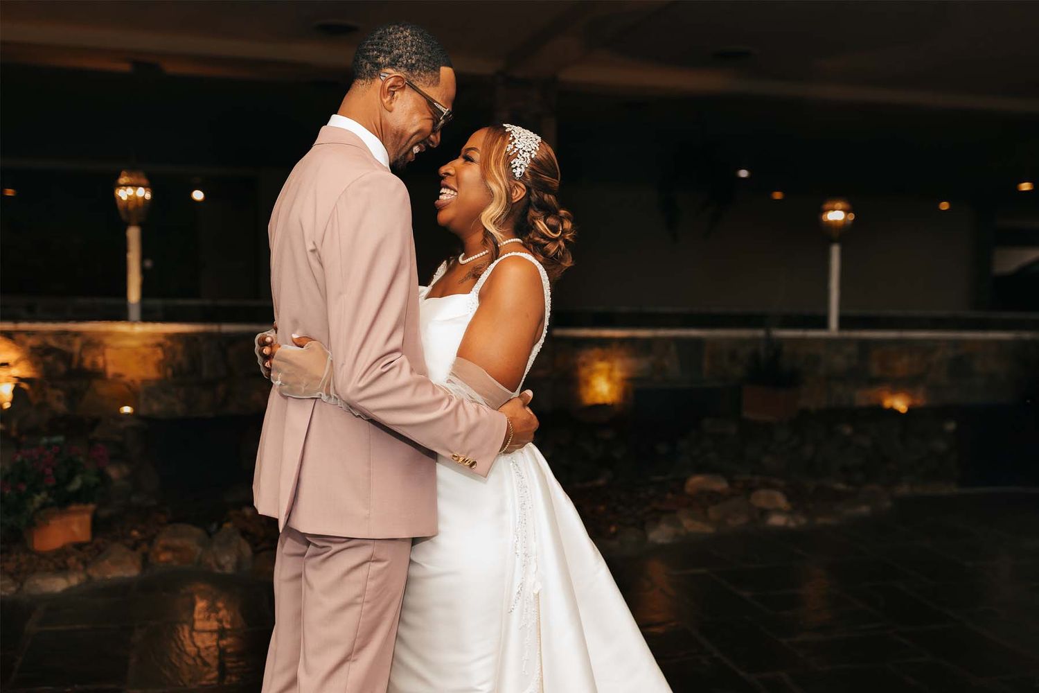 Romantic evening wedding reception dance captured with warm ambient lighting.