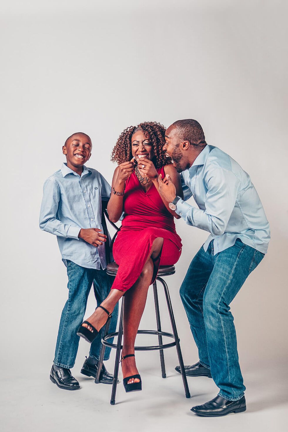 Studio photo sequence showing family members laughing and playing around a stool.
