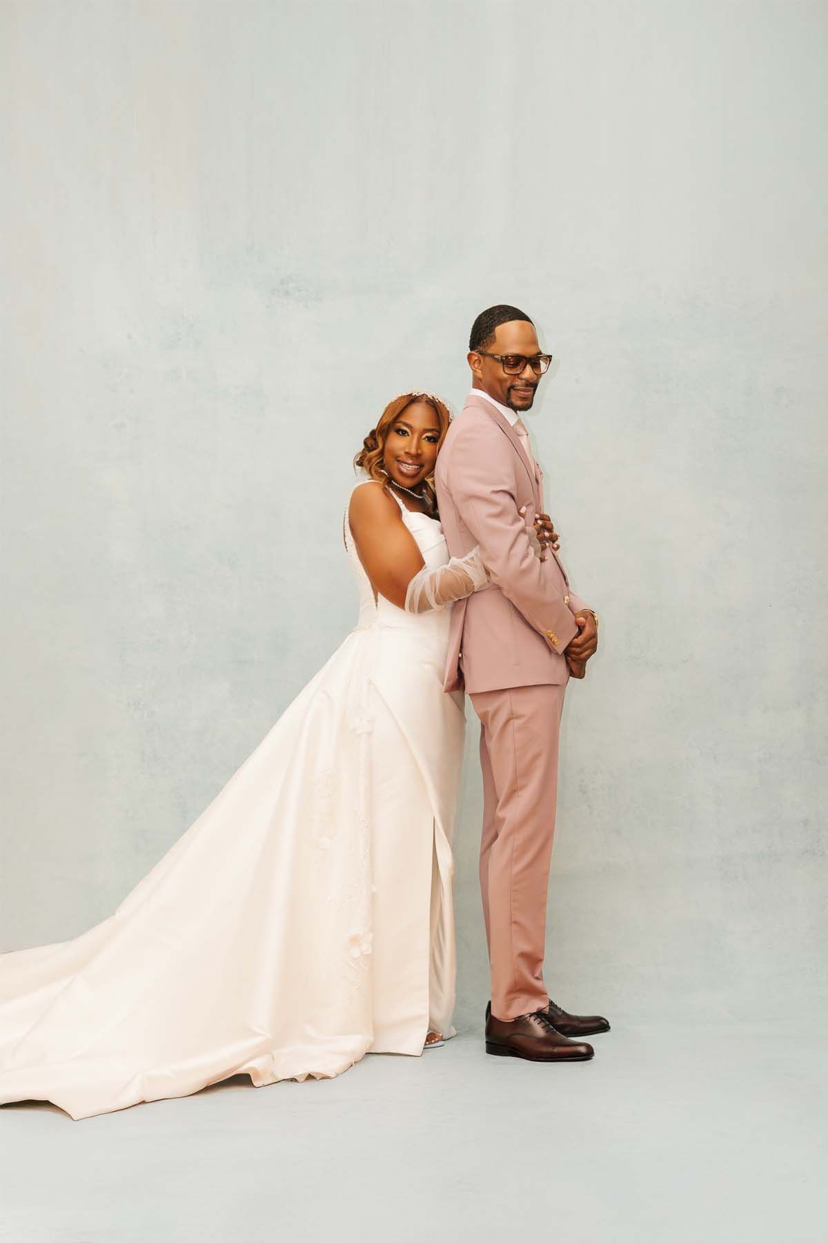 Artistic wedding photo series showing intimate poses in white dress and pink suit against grey backdrop.