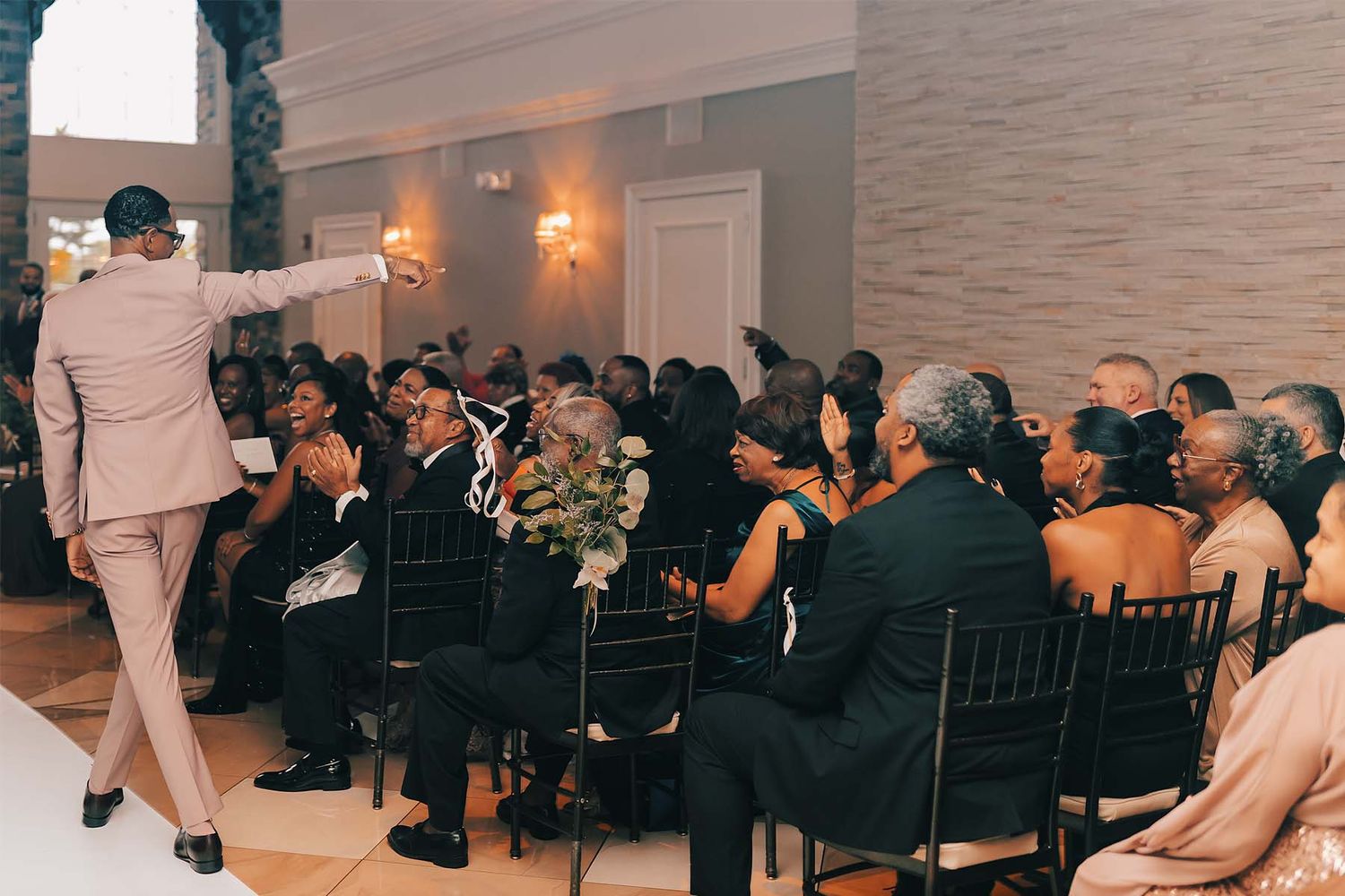 Wedding guests dancing and celebrating on a crowded dance floor at an elegant indoor reception.