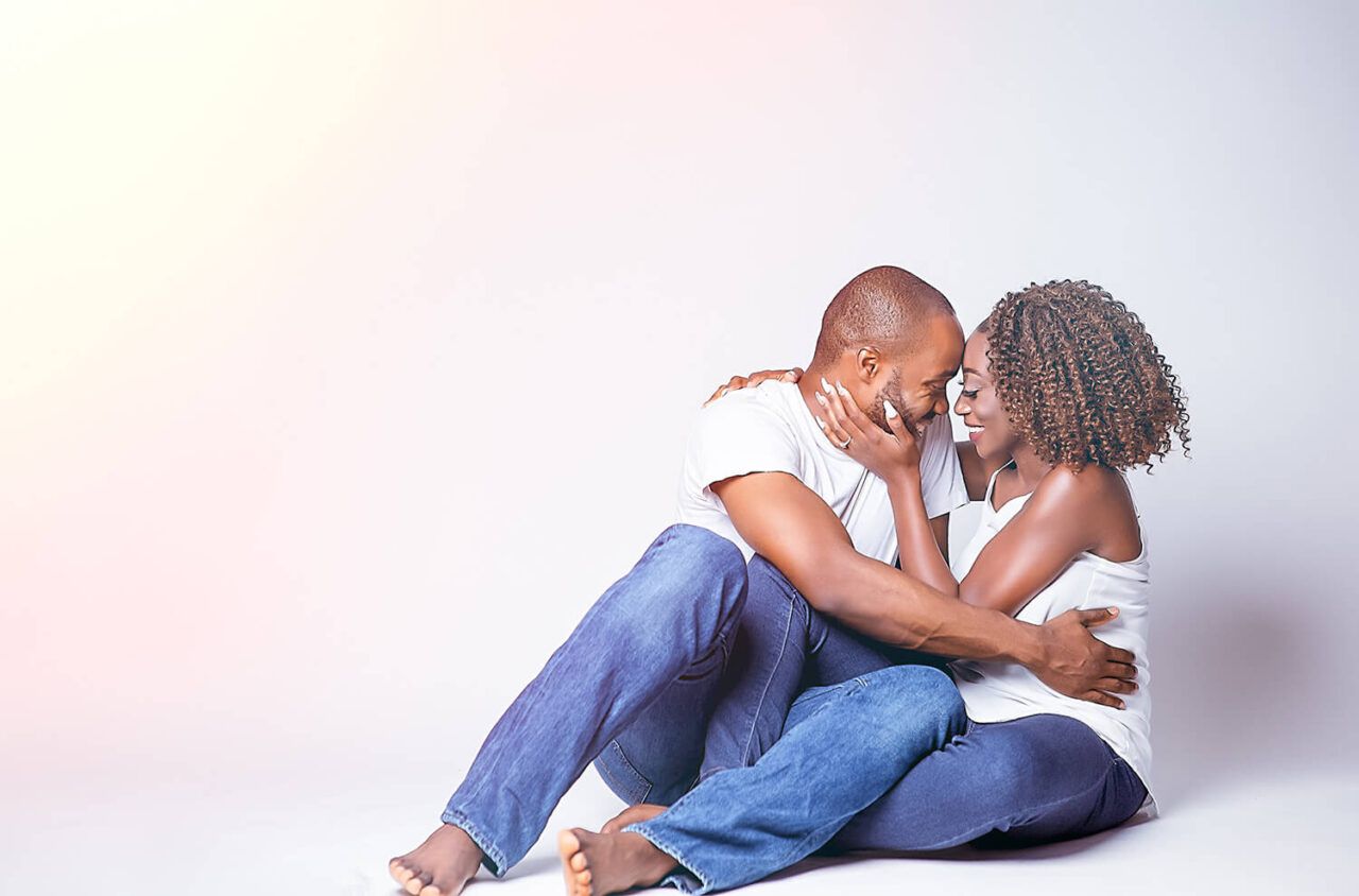 Couple in casual outfits sharing tender moments during professional photoshoot.