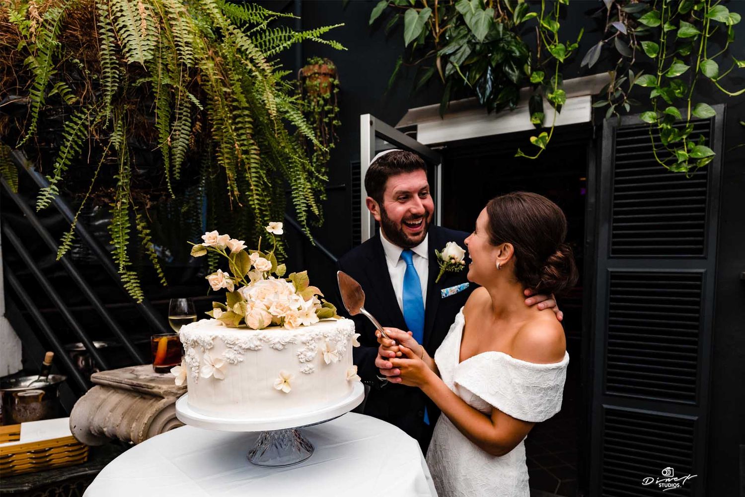 Wedding couple sharing intimate moments among tropical greenery and decor.