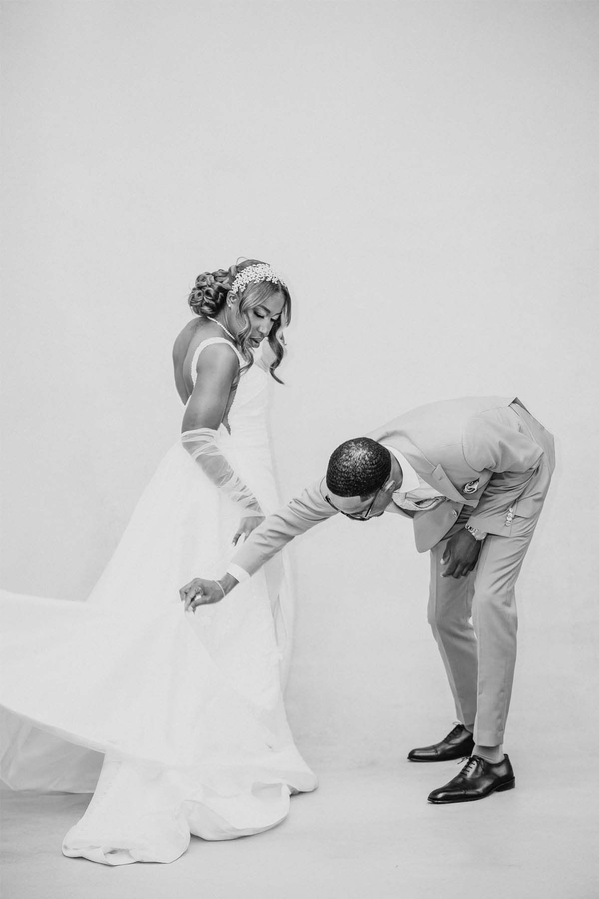 Black and white artistic wedding photos showing playful poses against white backdrop.