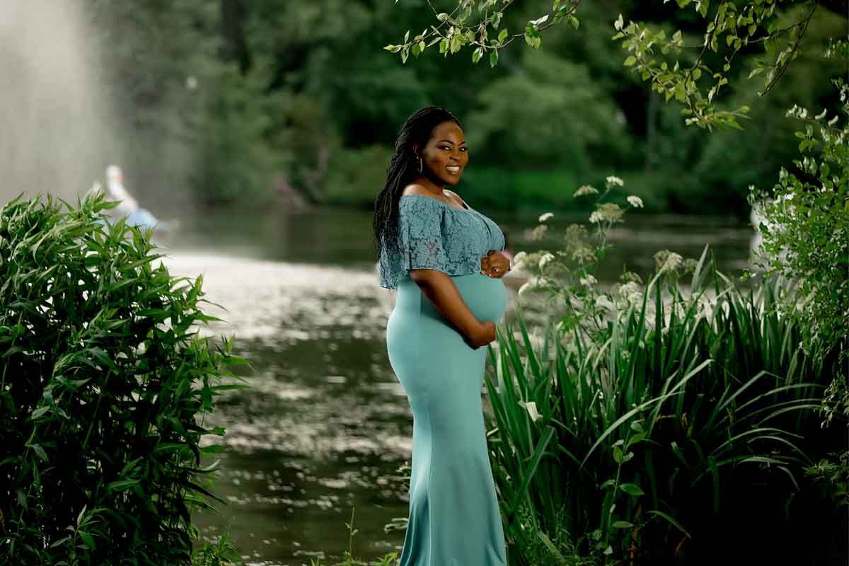 A romantic couple poses together in a lush garden setting wearing coordinated outfits.