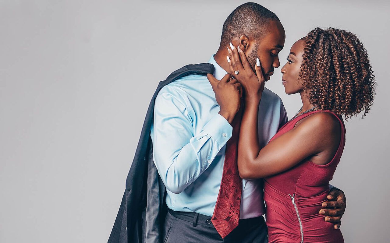 A tender moment between a couple in contrasting casual and formal wear.