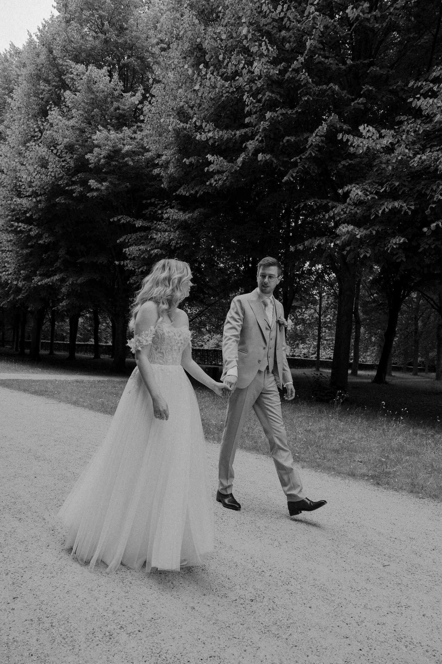 bruidspaar loopt romantisch hand in hand bij de trouwlocatie tijdens de love shoot