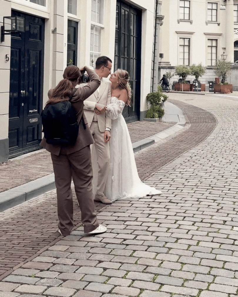 Trouwfotograaf is van bruidspaar foto's aan het maken in de stad van Dordrecht
