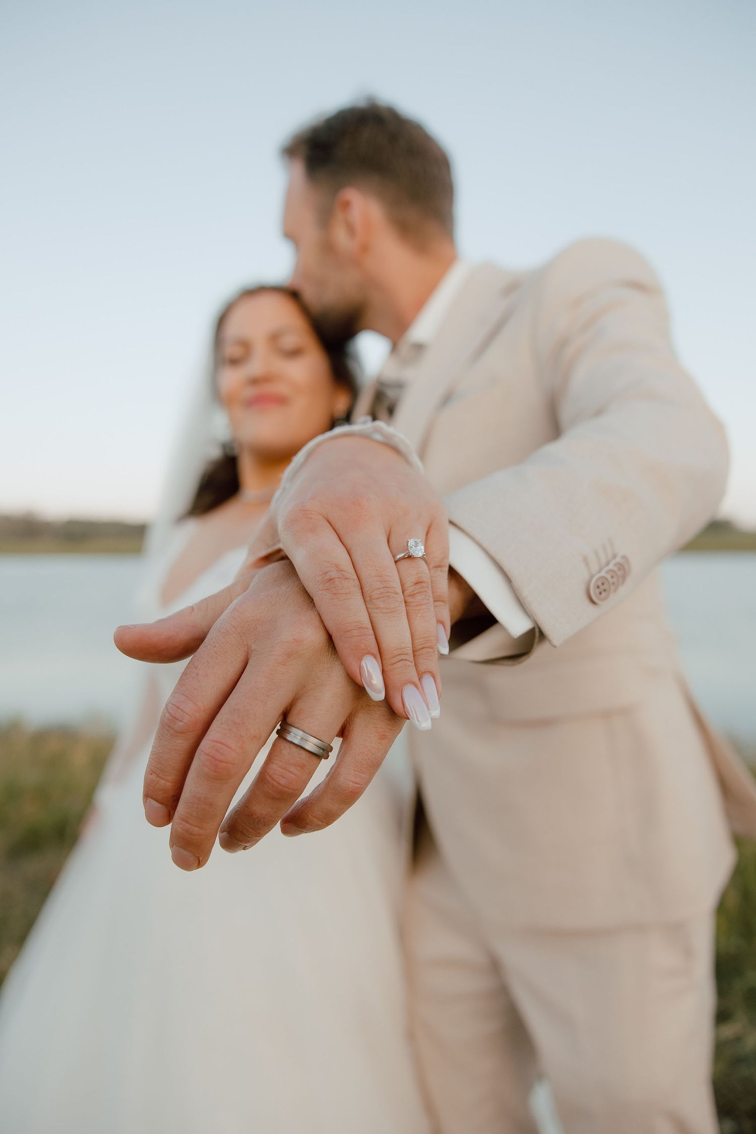 Bruidspaar laat ringen zien tijdens loveshoot met zonsondergang