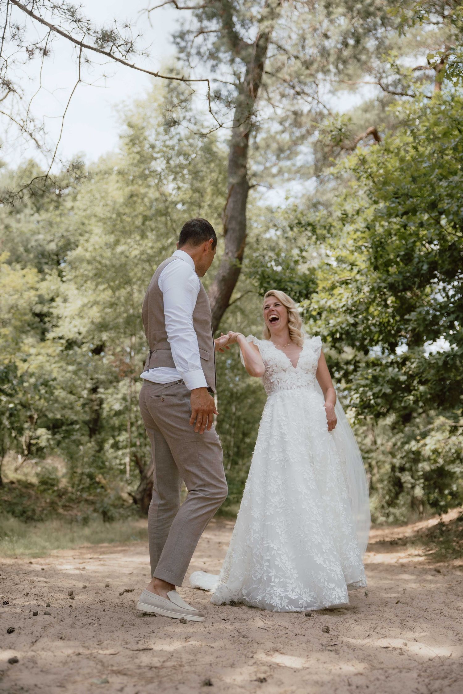 Bruidspaar doet dansje in het bos tijdens loveshoot - spontane trouwfotografie in Almere, Flevoland.