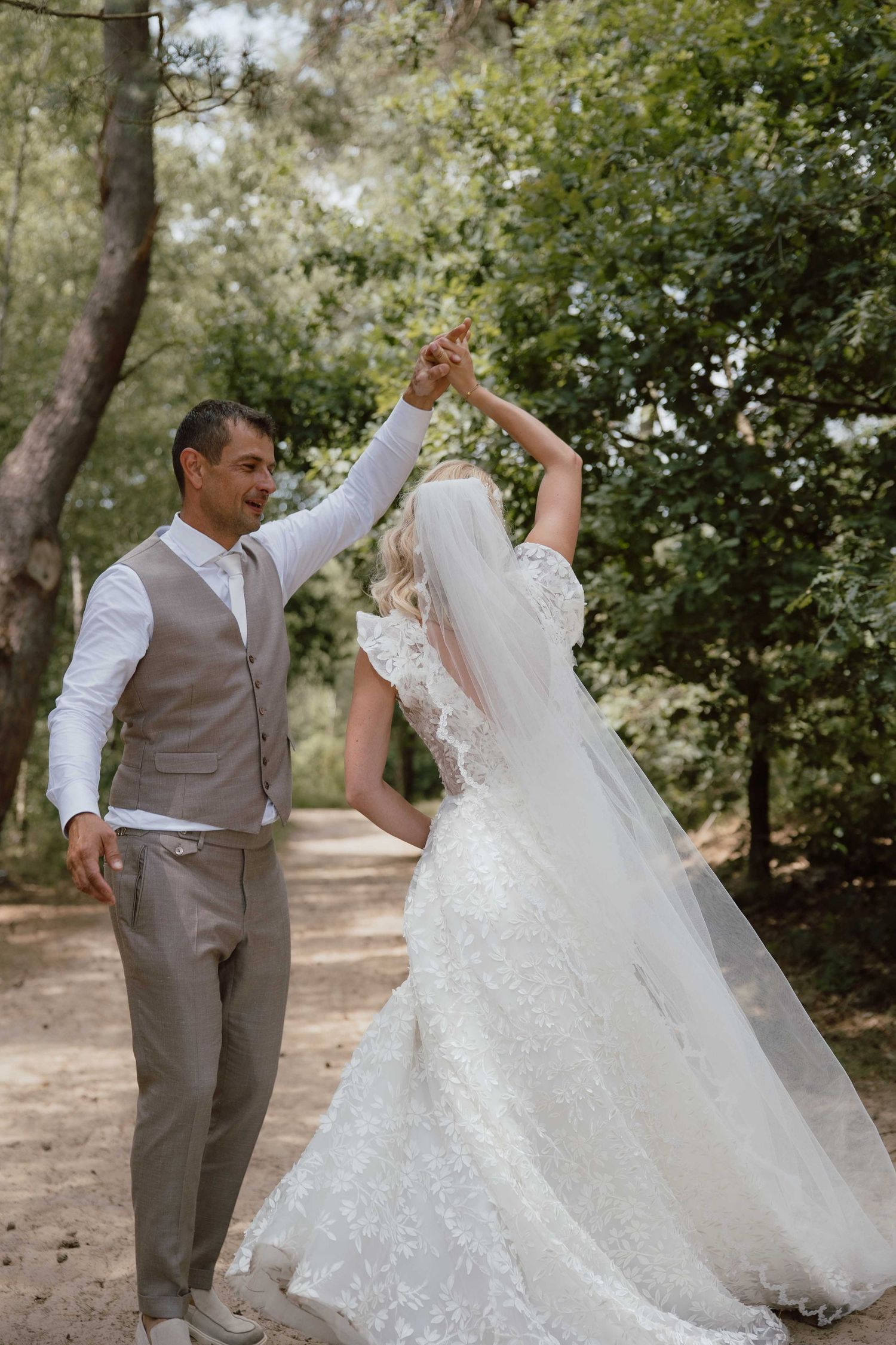 Bruidspaar doet dansje tijdens loveshoot - spontane trouwfotografie in Almere, Flevoland.