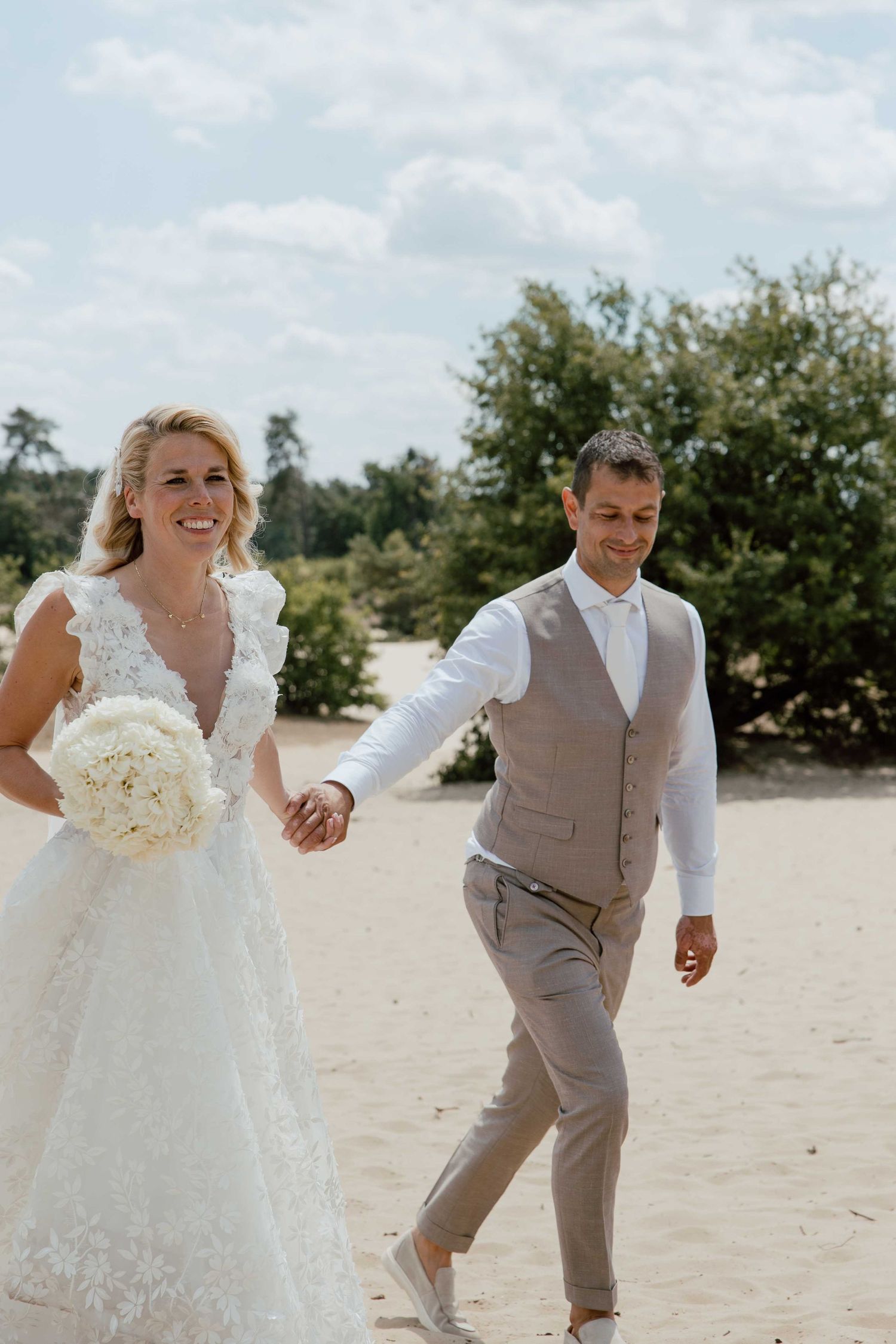 Bruidspaar op zandvlakte tijdens loveshoot - spontane trouwfotografie in Almere, Flevoland.