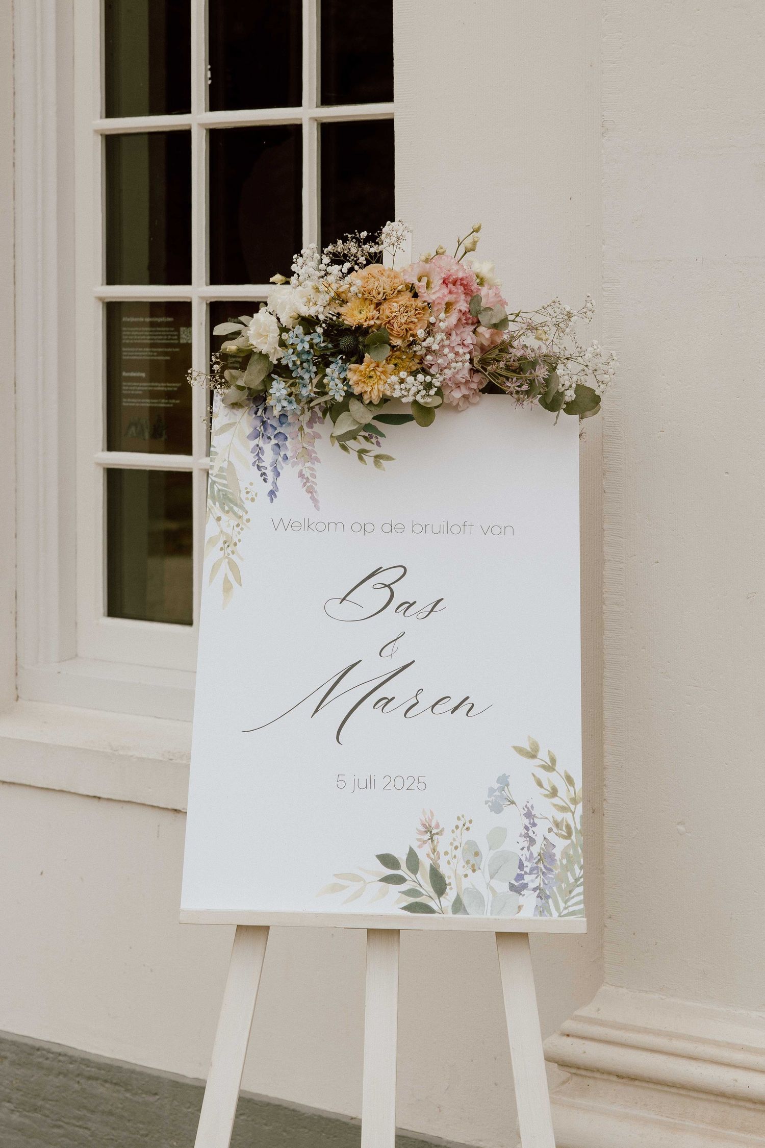 Welkomstbord van bruidspaar met bloemen