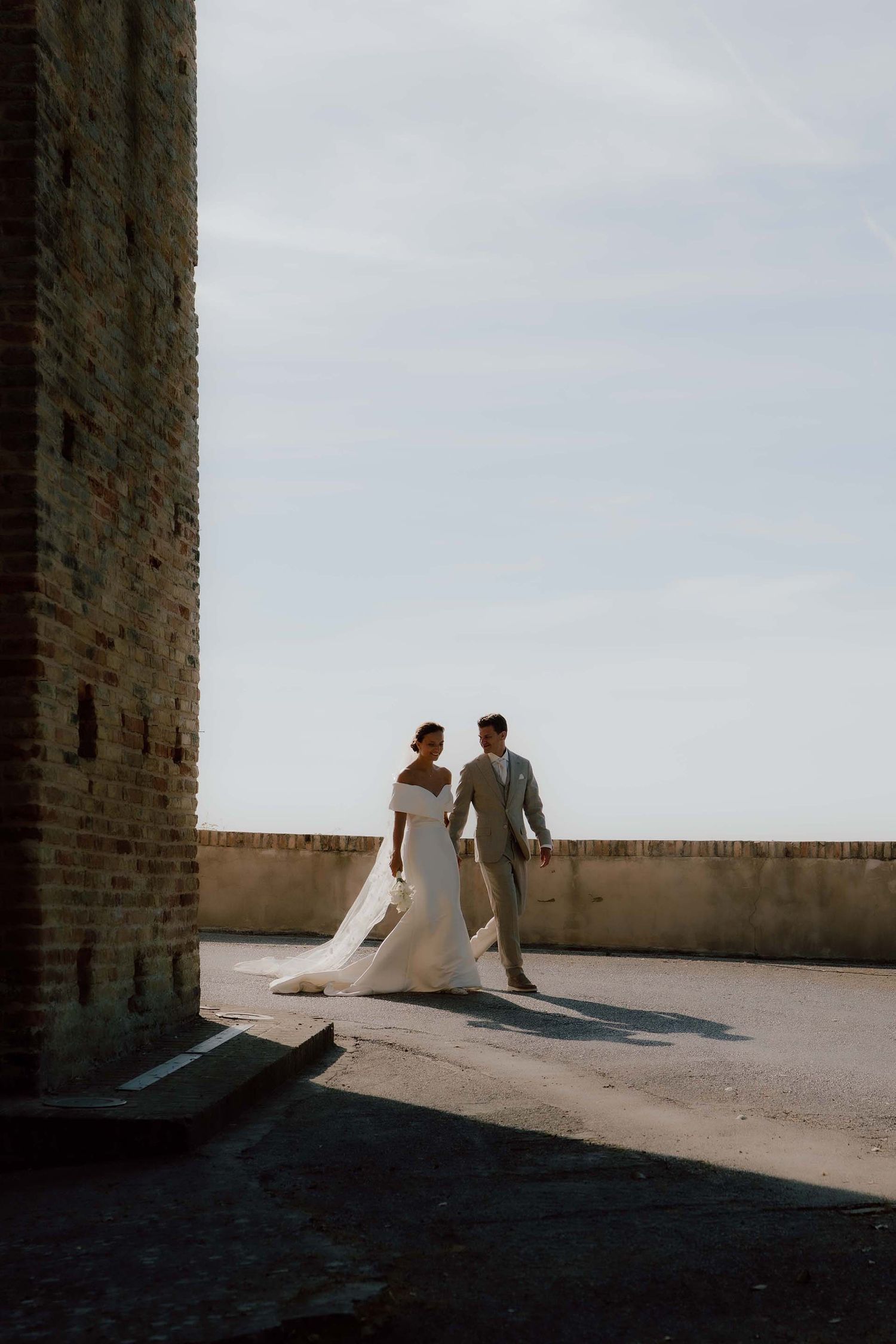 Bruidspaar loopt tijdens de fotoshoot op de weg op hun trouwdag