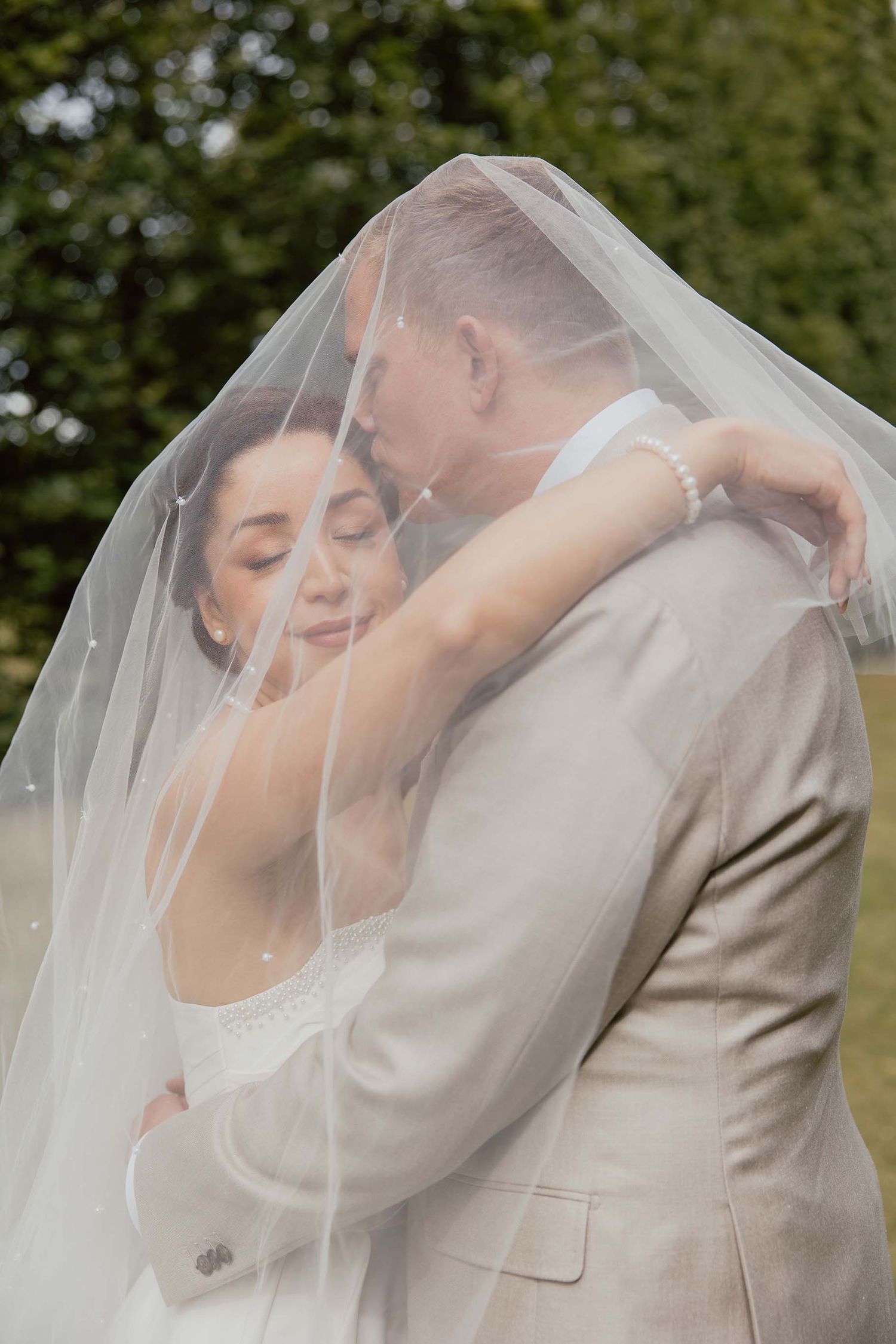 Bruidspaar tijdens loveshoot samen onder de sluier bij Oranjerie Elswout