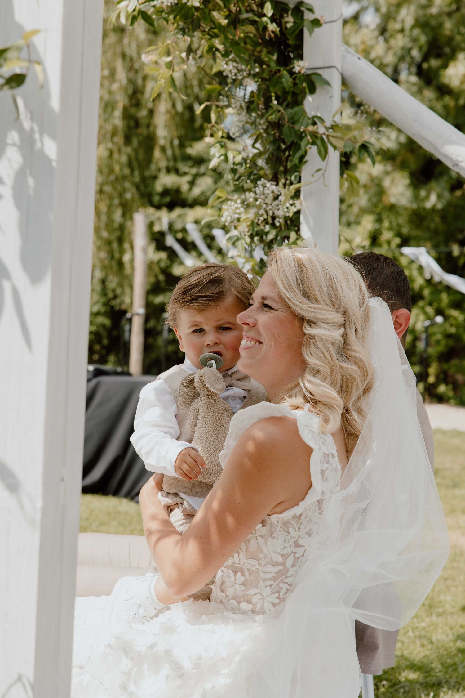 Zoontje op schoot bij bruid tijden de ceremonie - spontane trouwfotografie in Almere, Flevoland.