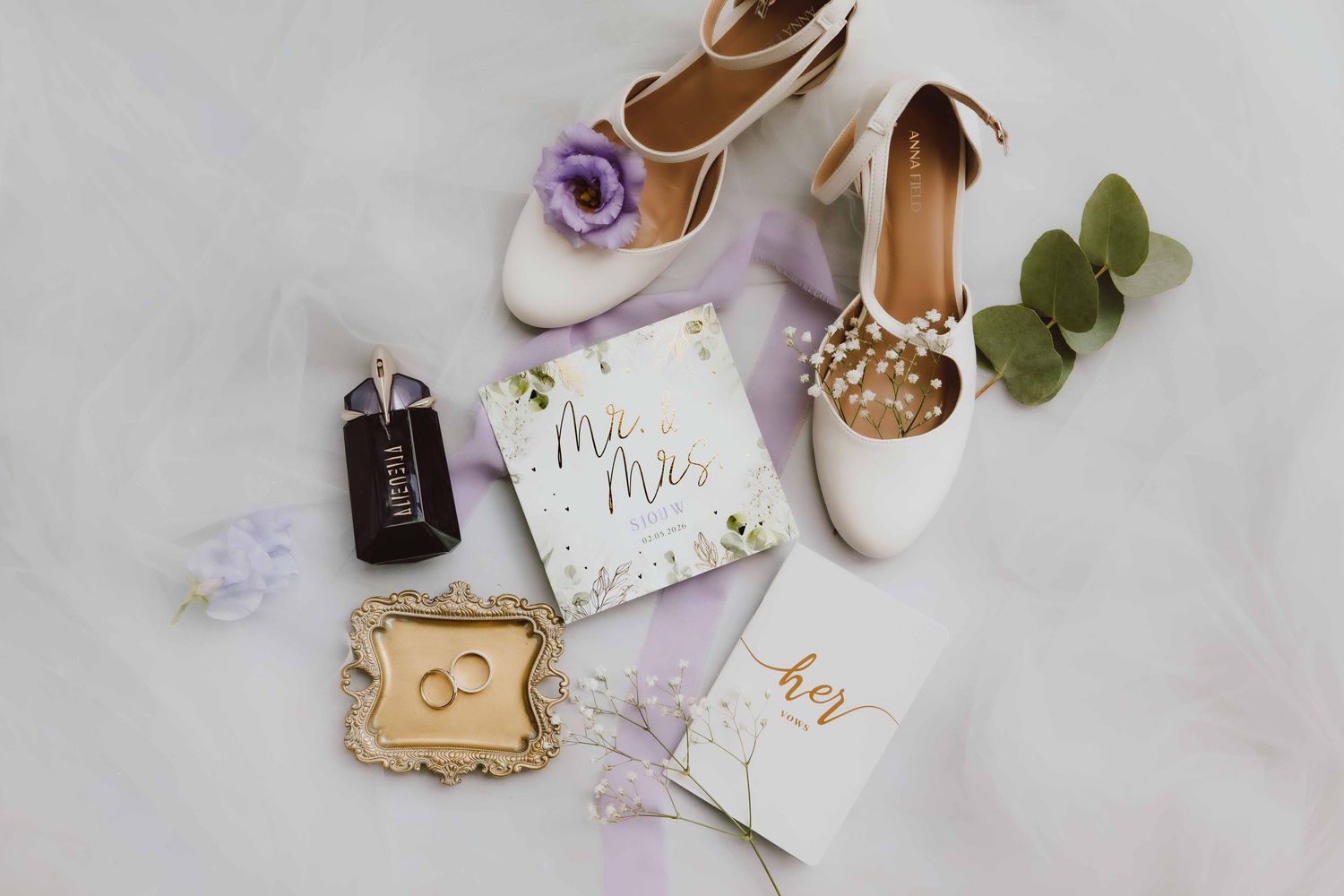 Flatlay met alle details van de trouwdag zoals de trouwschoenen, trouwringen, trouwkaart