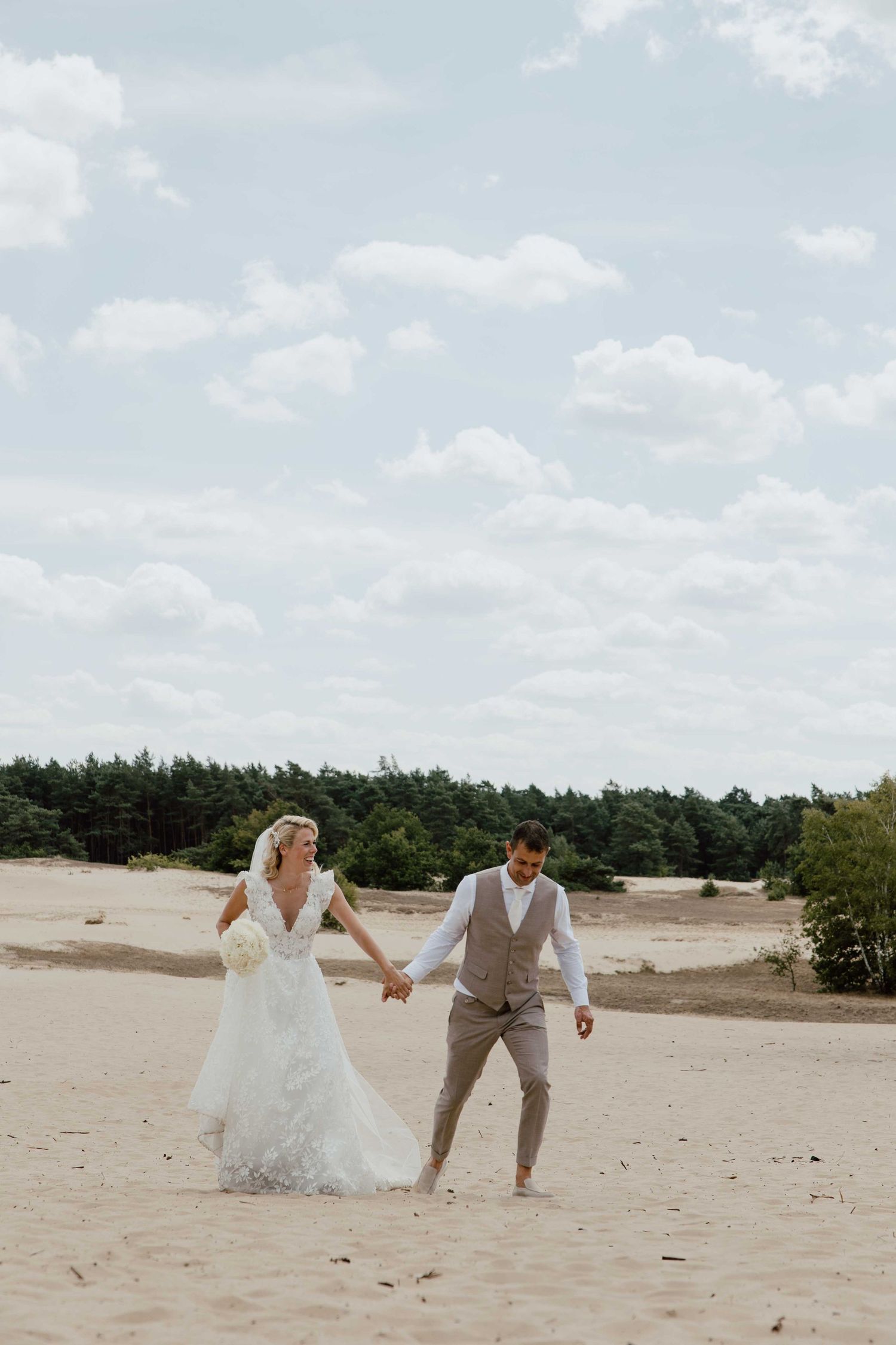 Bruidspaar rent samen - spontane trouwfotografie in Almere, Flevoland.