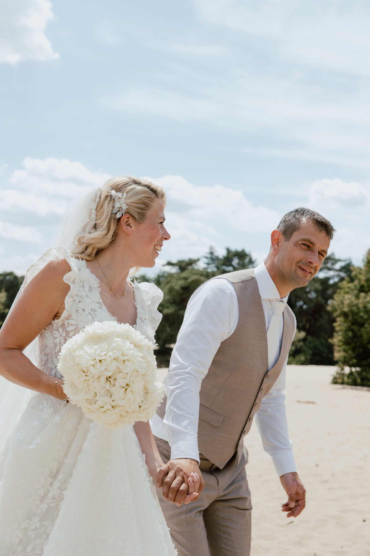 Bruidspaar op zandvlakte tijdens loveshoot - spontane trouwfotografie in Almere, Flevoland.