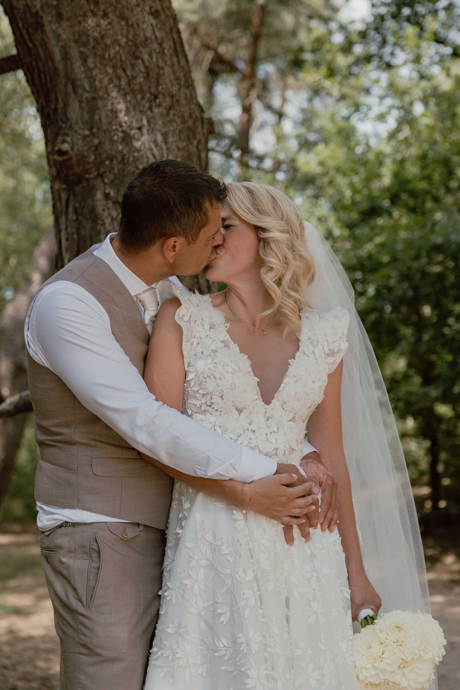 Bruidspaar geeft elkaar kus tijdens loveshoot in het bos - spontane trouwfotografie in Almere, Flevoland.