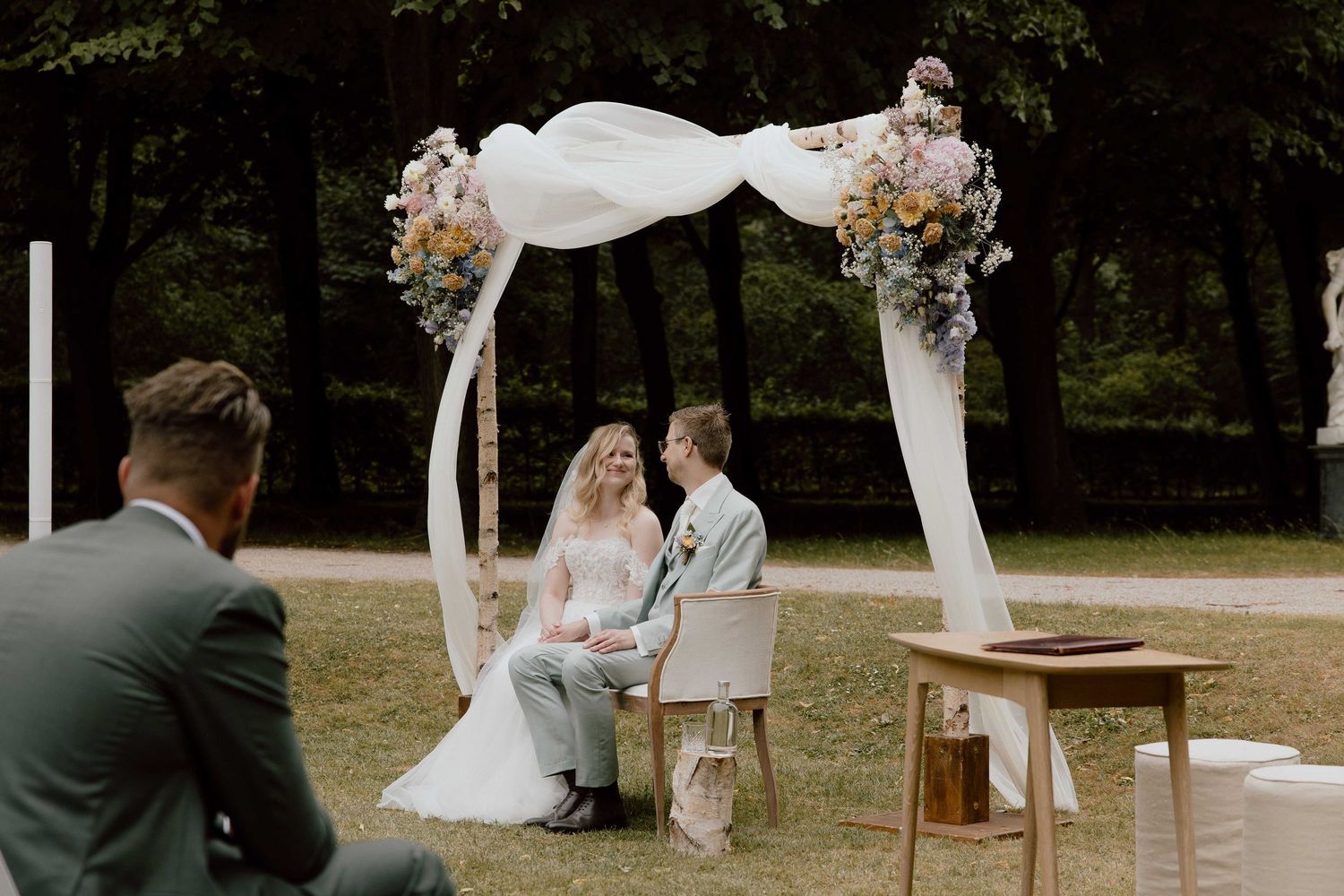 Bruidspaar kijkt elkaar aan tijdens de ceremonie bij Buitenplaats Beeckestijn