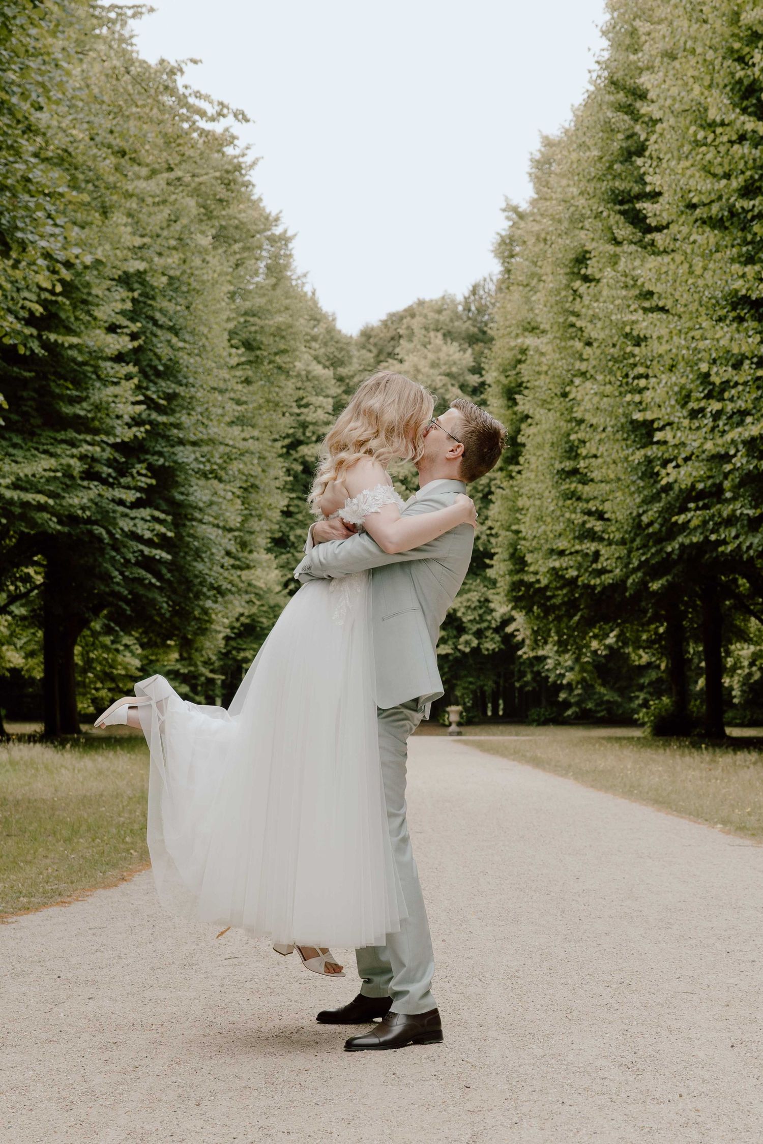 bruidegom tilt bruid op tijdens de loveshoot in het bos