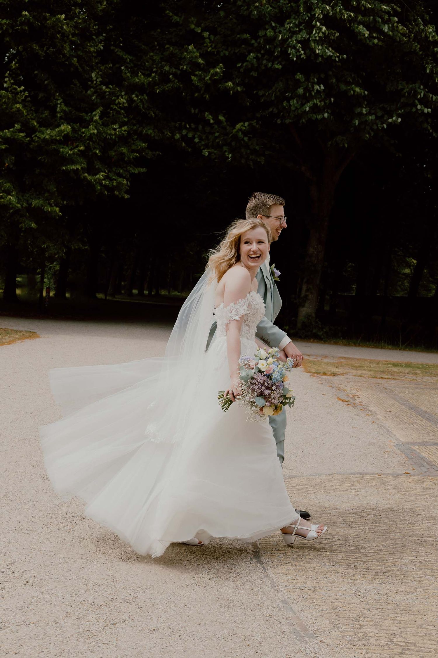 Bruidspaar loopt weg na de ceremonie bij Buitenplaats Beeckestijn