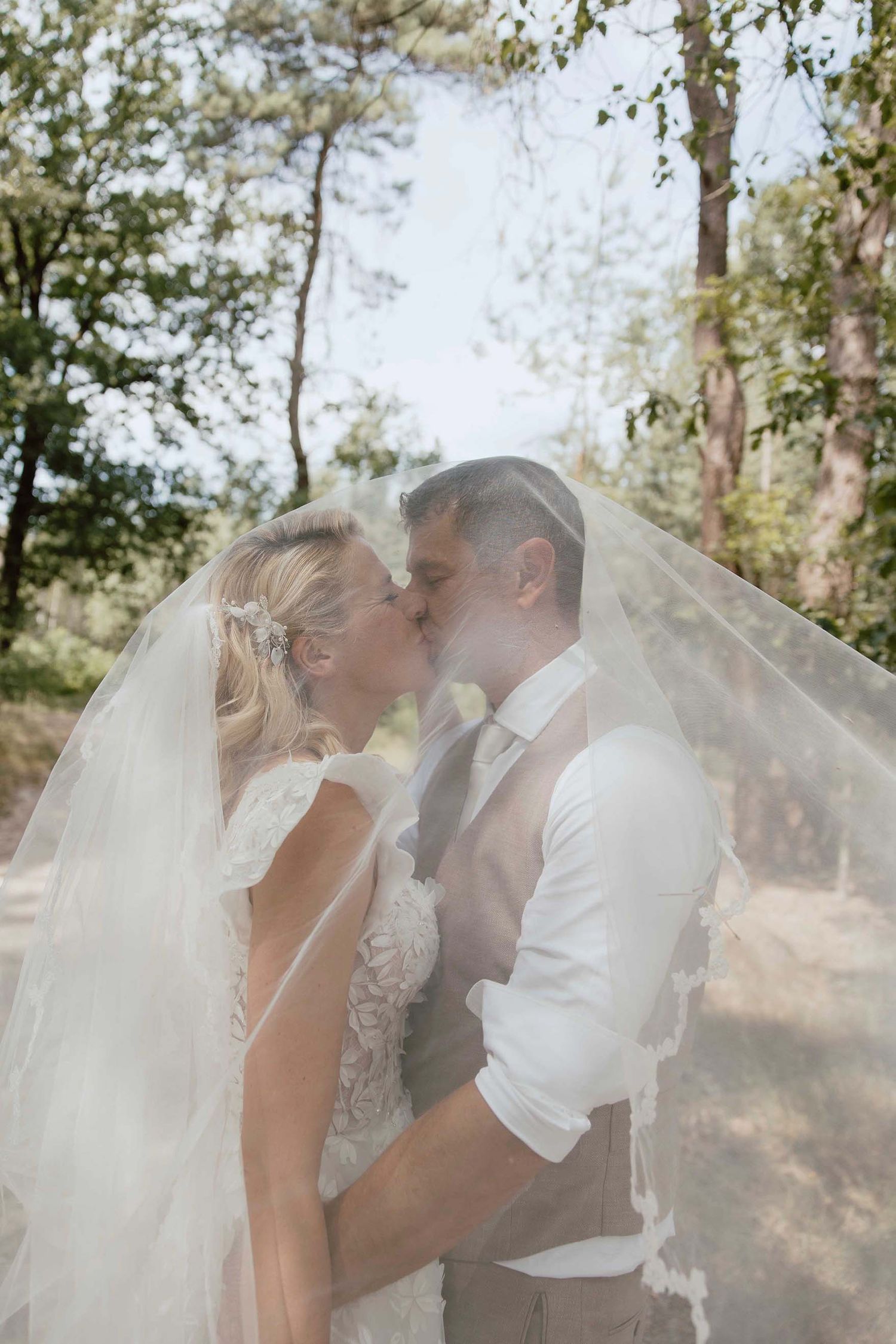 Bruidspaar tijdens loveshoot op de Veluwe romantisch onder de sluier
