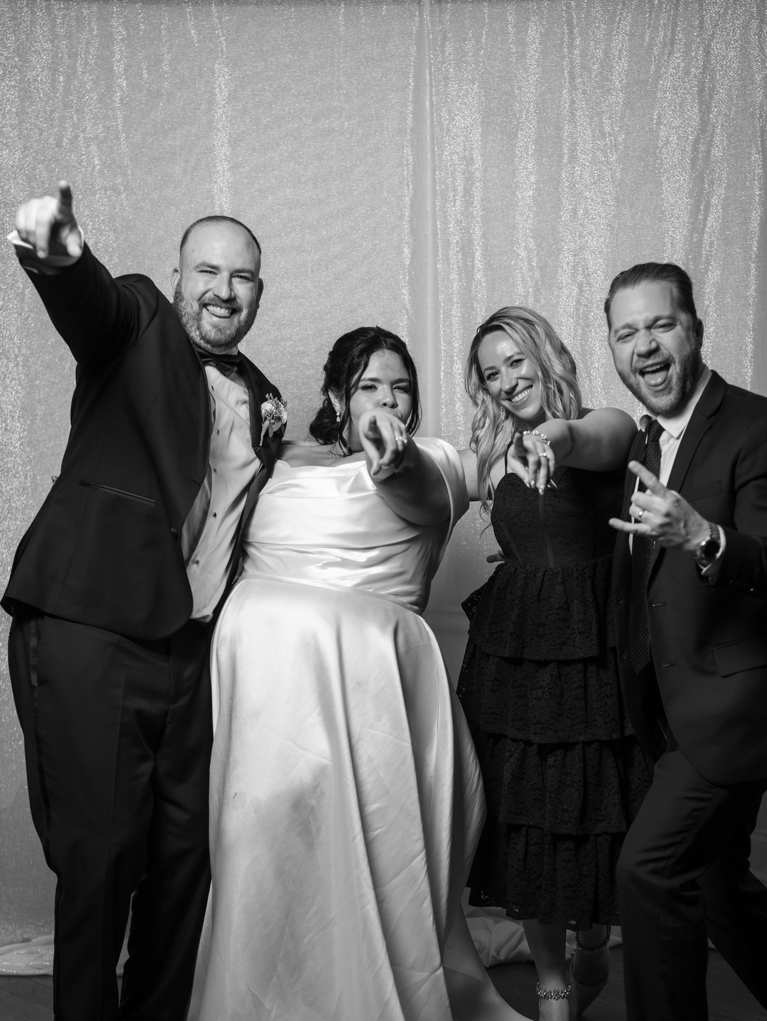 Bride and groom celebrate with friends in black and white wedding photo booth picture.