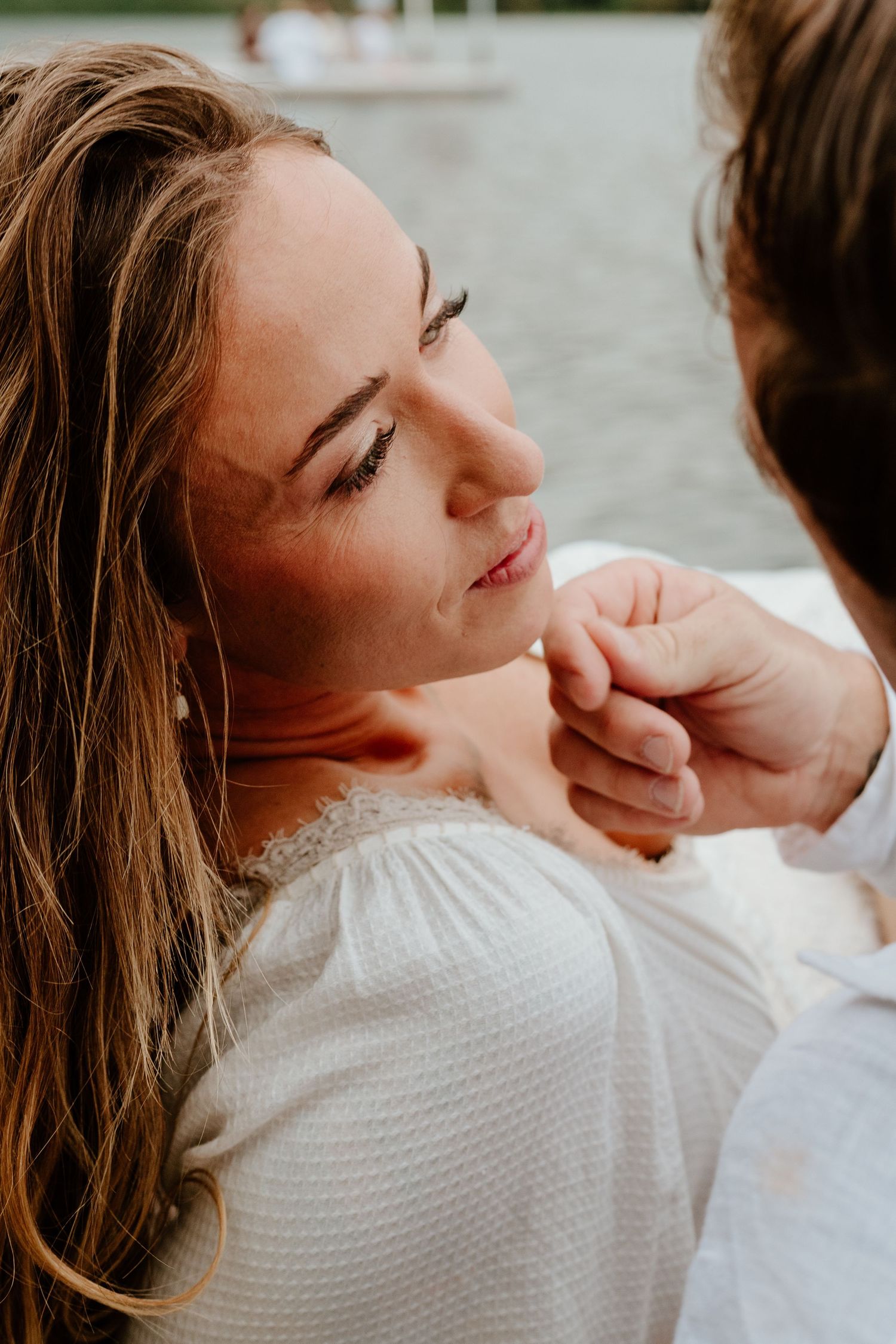 Man tenderly touching womans chin during a romantic beach session.