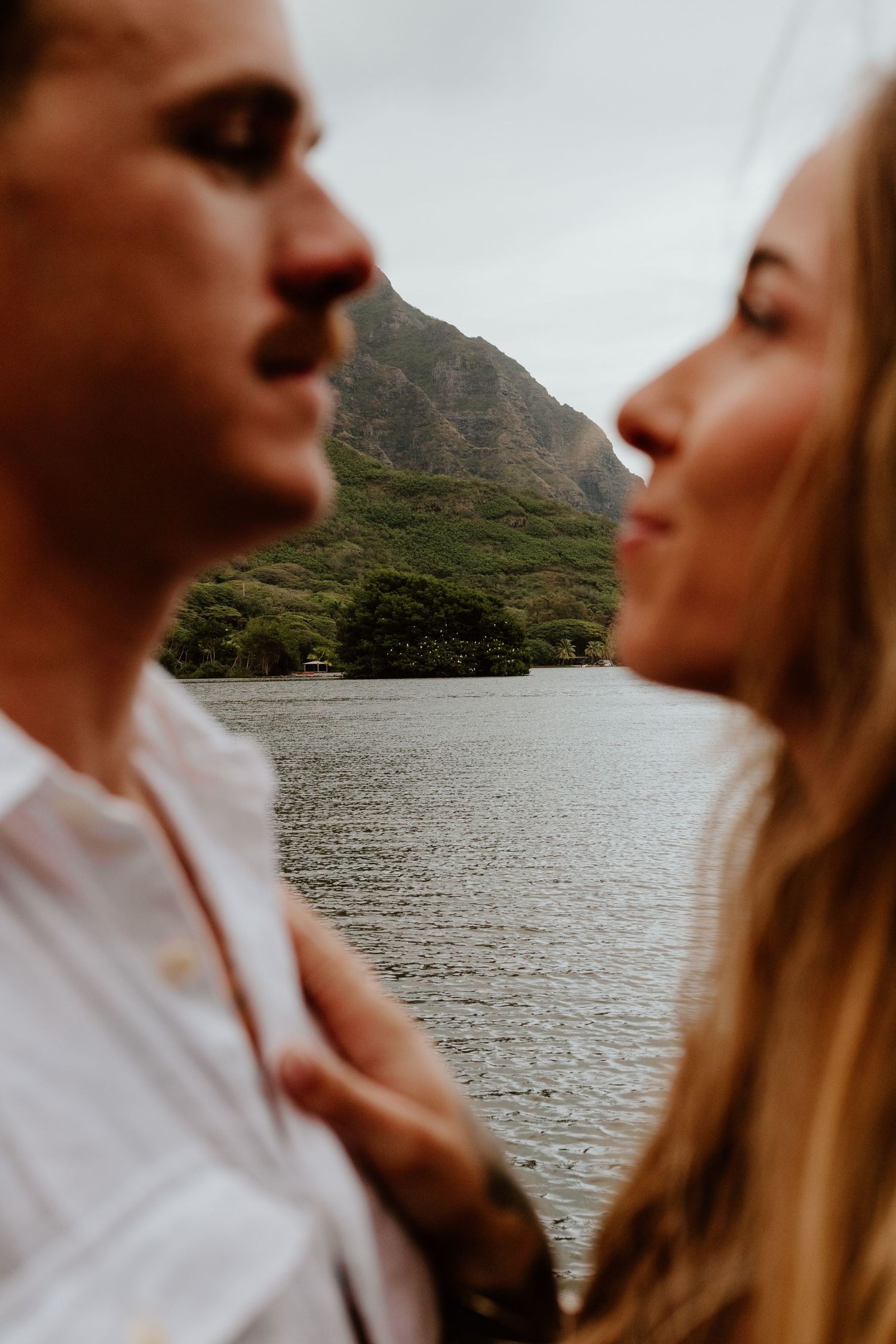 Couple gazing at each other with a mountain lake in background.