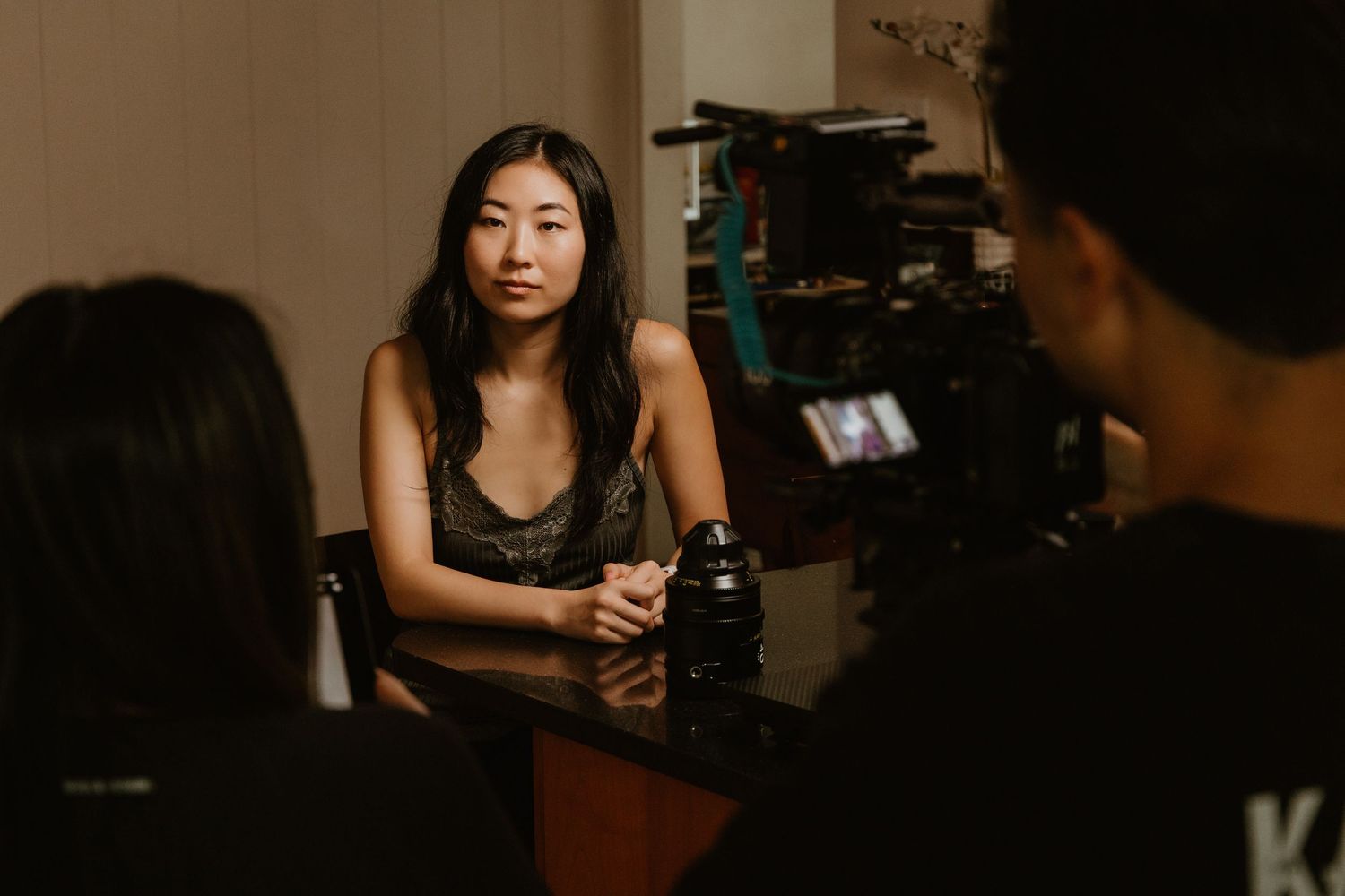 Young Asian woman being filmed during an interview on a professional video production set.