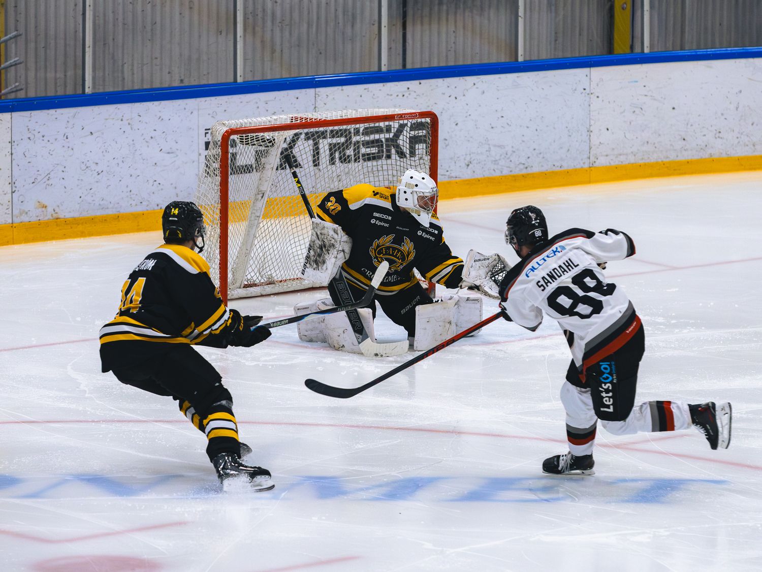 Hockey players battle for the puck near the goal during an intense game moment.